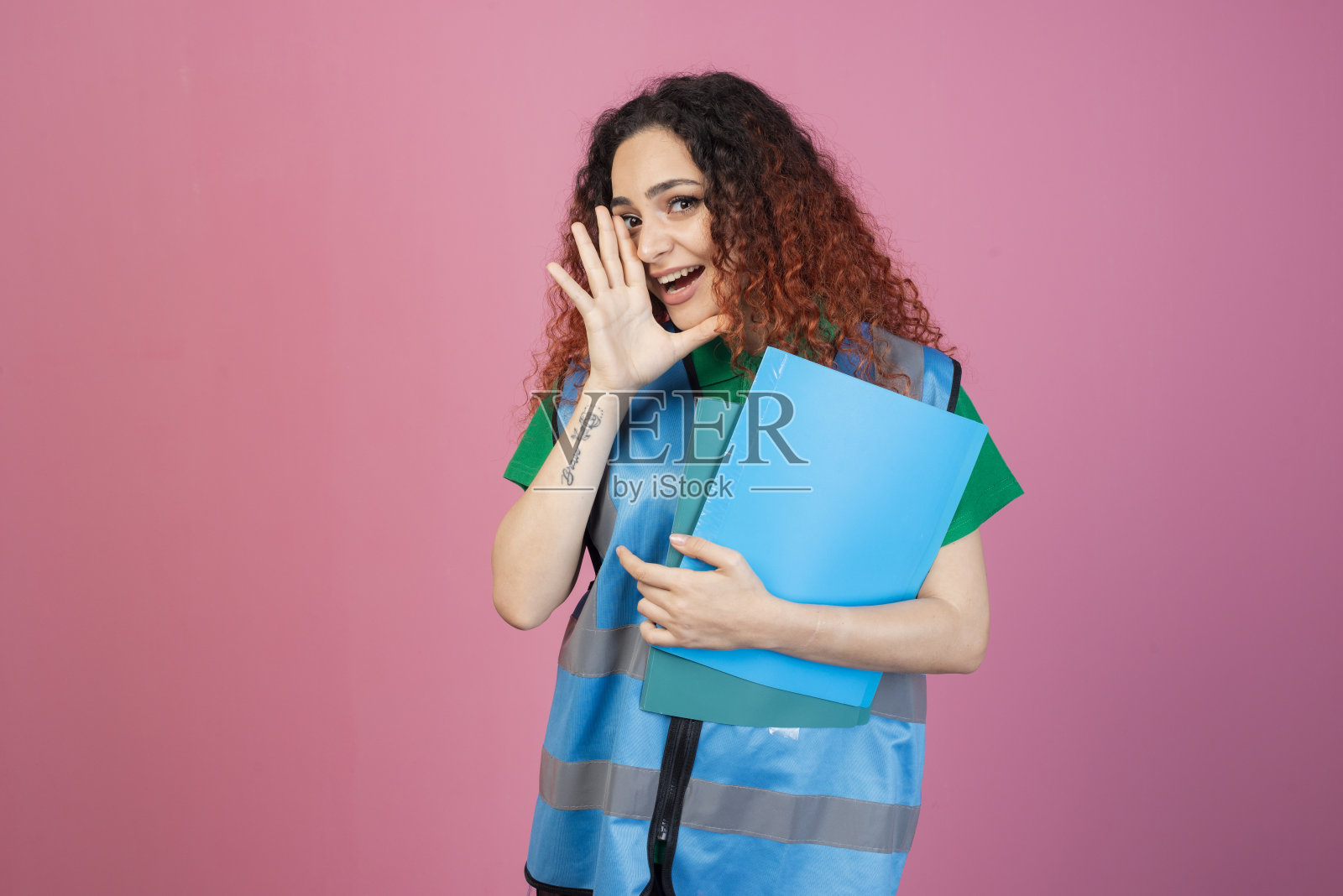 开朗的年轻女士穿着背心，站着，看着镜头，举手，哭泣。照片摄影图片