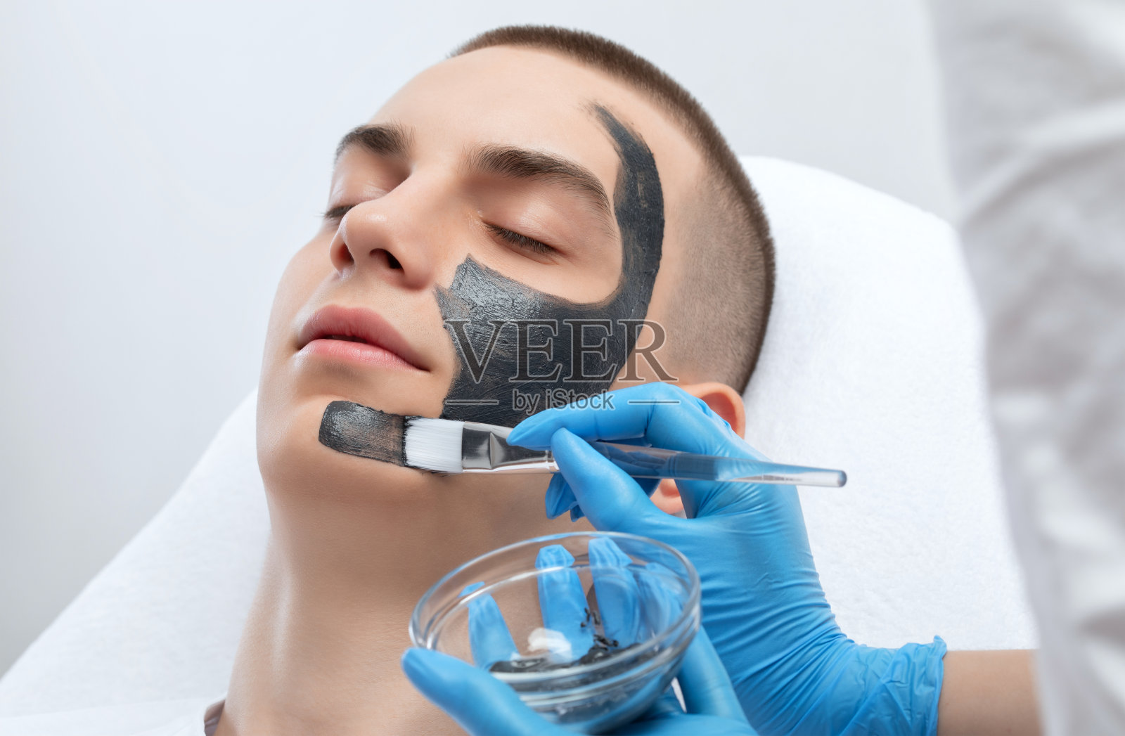 美容师在美容院给帅哥做碳剥离手术。五金男性美容。照片摄影图片