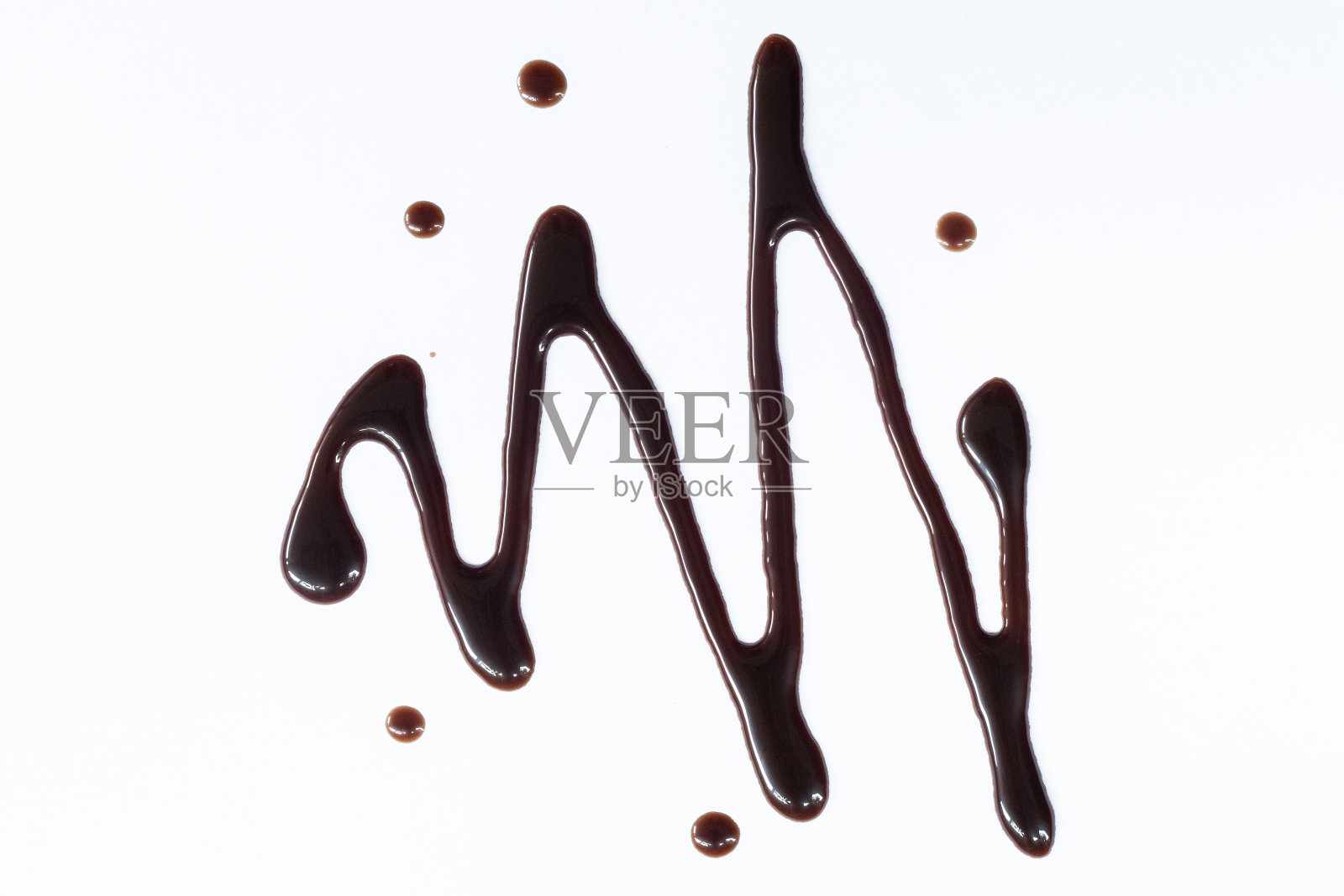 巧克力糖浆淋在白色的背景上。淋上一层甜巧克力酱。前视图。照片摄影图片