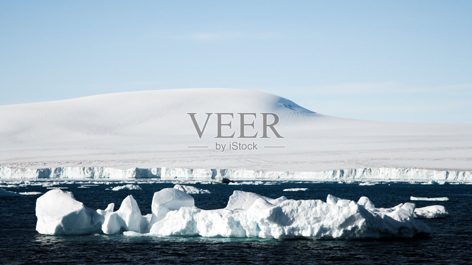 冰雪覆盖的南极海岸前的冰山照片摄影图片