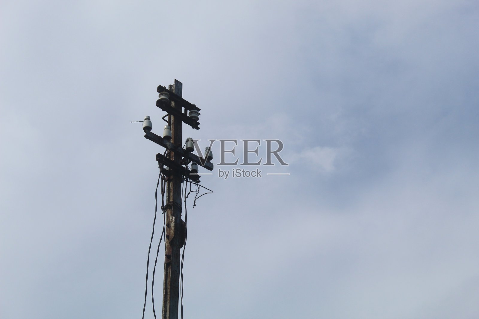 电线杆和混乱的电线映衬着清晨明亮的蓝天照片摄影图片