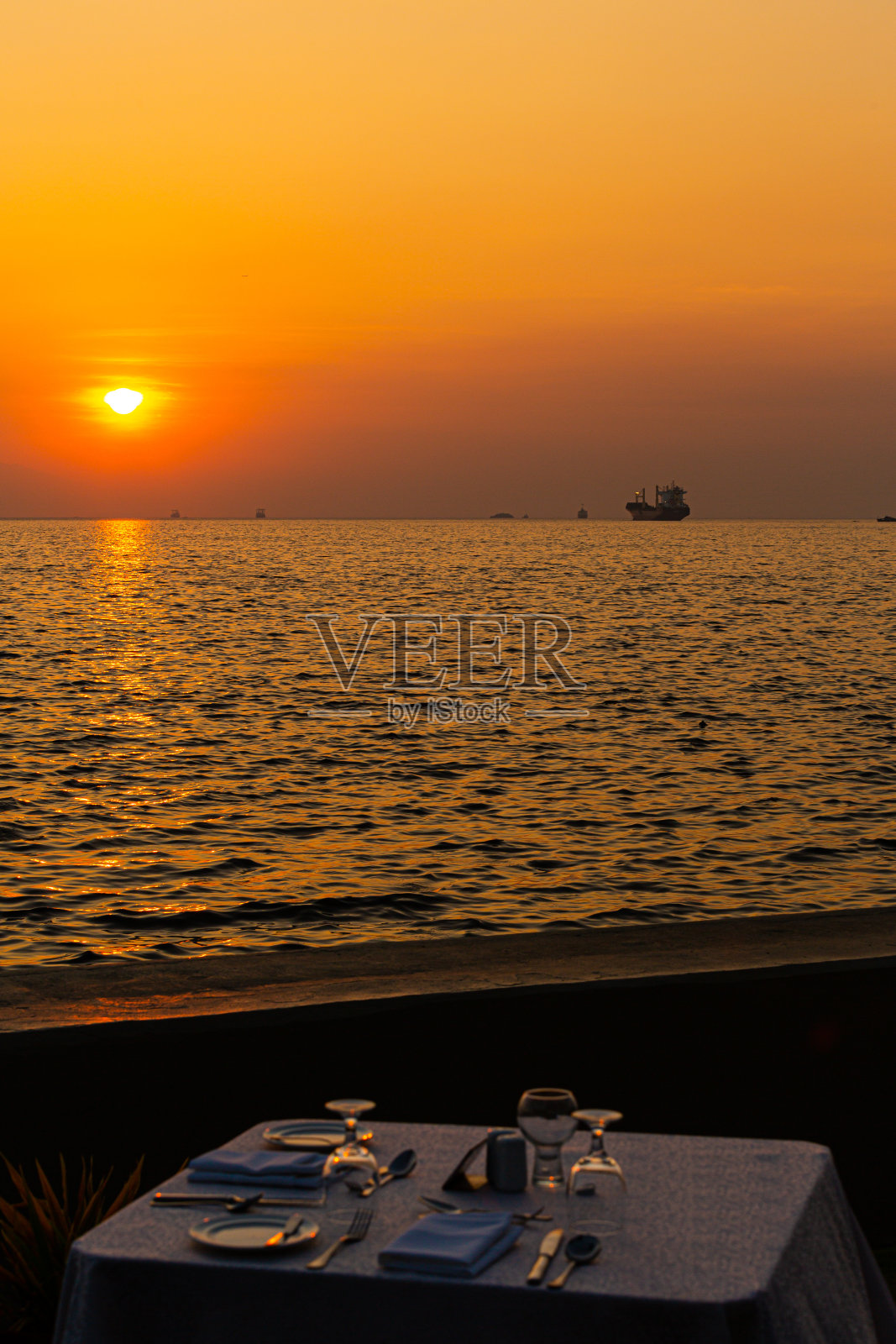 令人惊叹的浪漫餐桌在户外海滩餐厅。度假，蜜月浪漫爱情，豪华目的地餐饮，异国情调的海景餐桌照片摄影图片