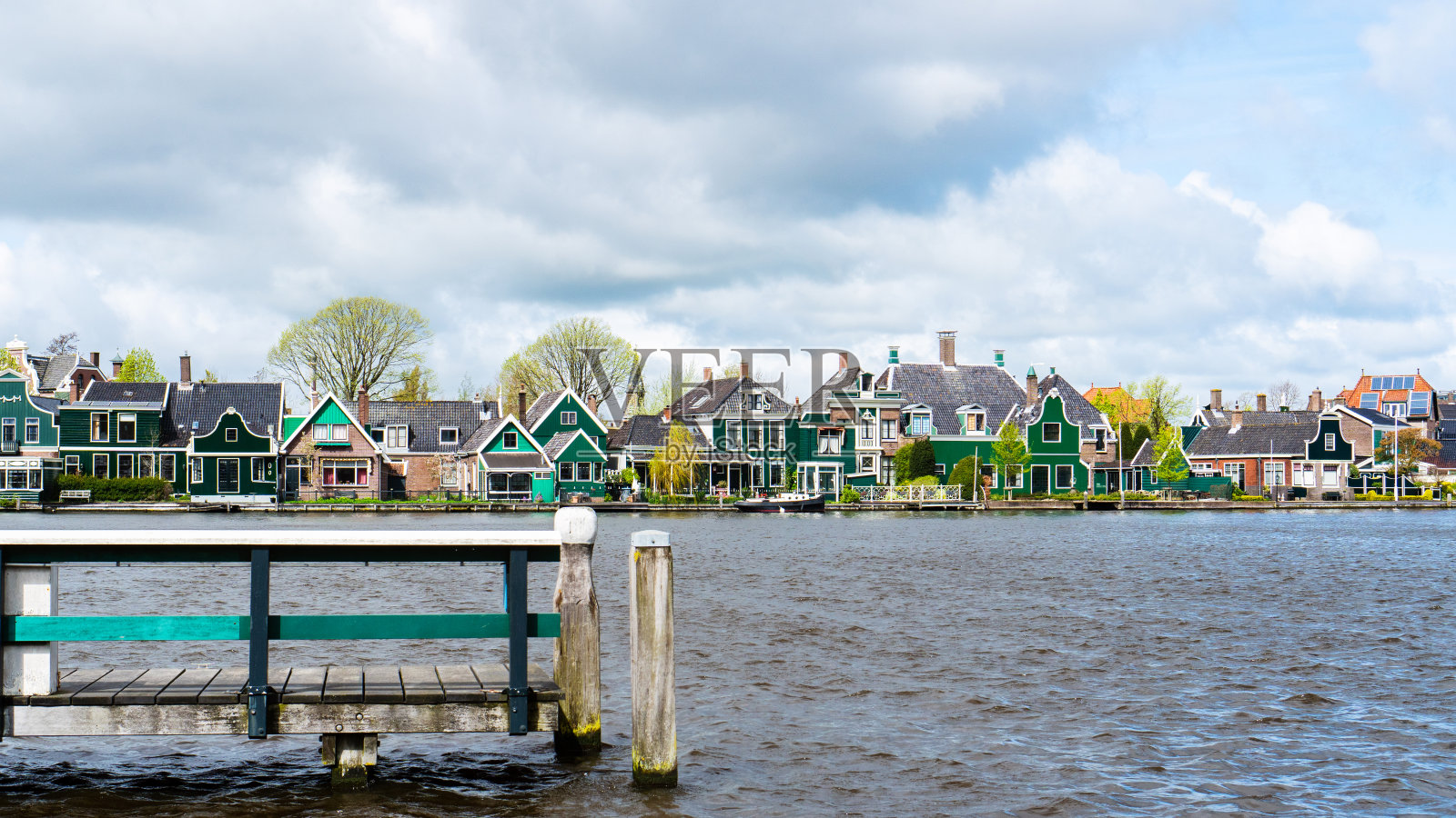 阿姆斯特尔河上的木码头。在赞丹的早春，荷兰风格的乡村风景如画。早春时节，湖边天气寒冷，阳光明媚，有风。春天的海景。照片摄影图片