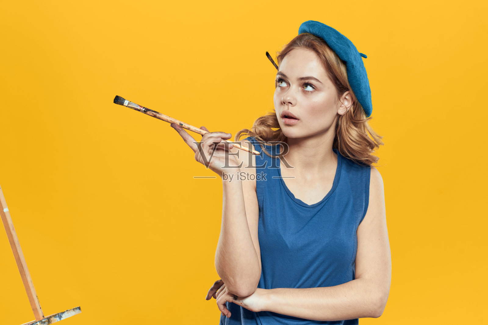 艺术家女子在蓝色贝雷帽刷画架艺术绘画教育爱好创作方法黄色背景照片摄影图片