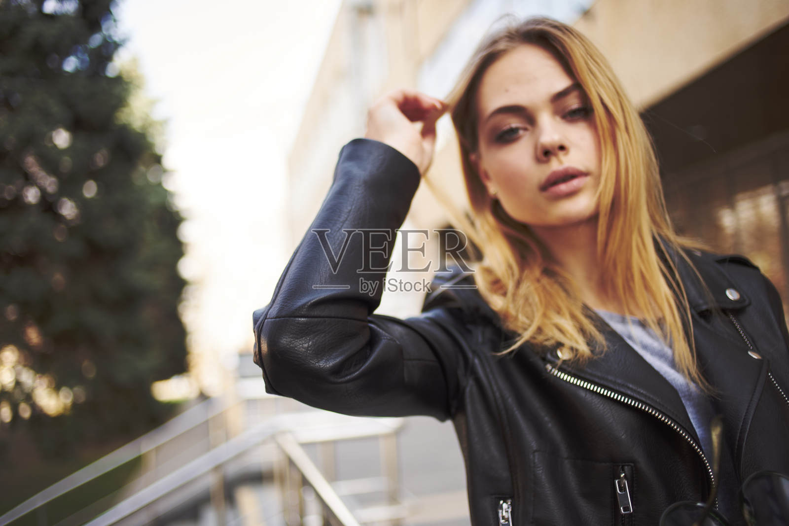 一名穿着皮夹克的妇女在街模购物大楼旁的肖像照片摄影图片