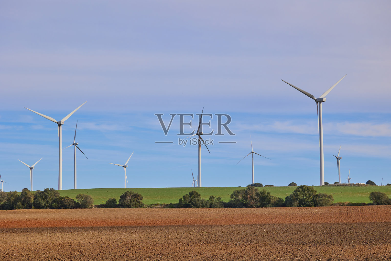 蓝天下农田的风力涡轮机景观照片摄影图片