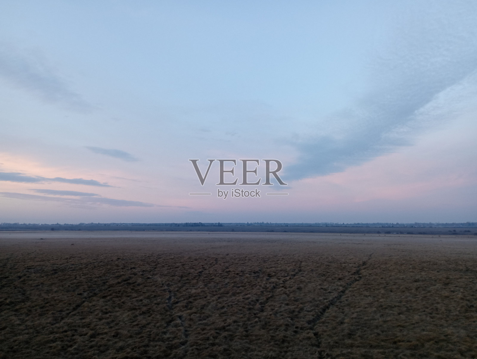 日落时美丽的风景。深红的夜空映在一望无际的大草原上。照片摄影图片