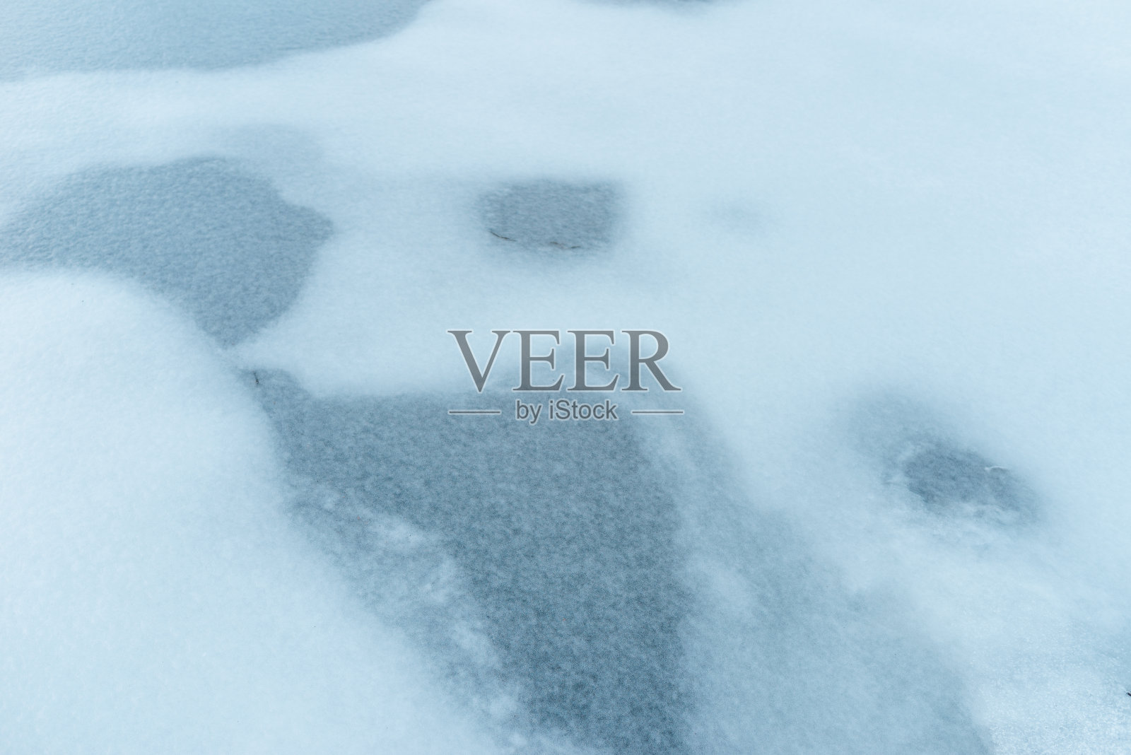 冷冻水。蓝色的冰在冬天结冰，湖面上有雪和裂缝。湖面上的冰融化了，春天来了。关闭了。照片摄影图片