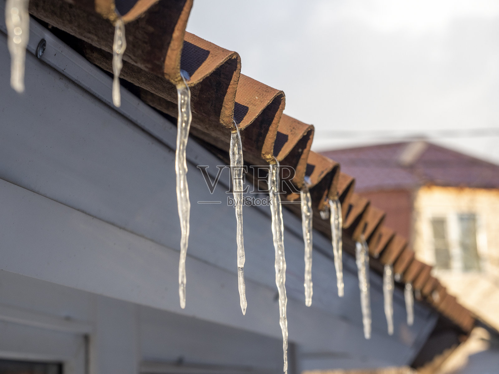 冰柱挂在屋顶上。特写，选择性聚焦照片摄影图片