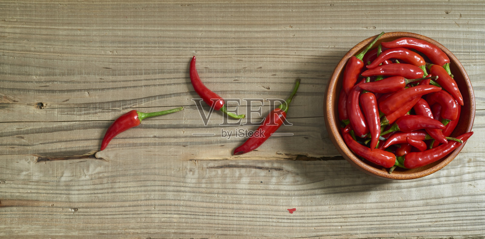 红辣椒碗在旧木背景。照片摄影图片
