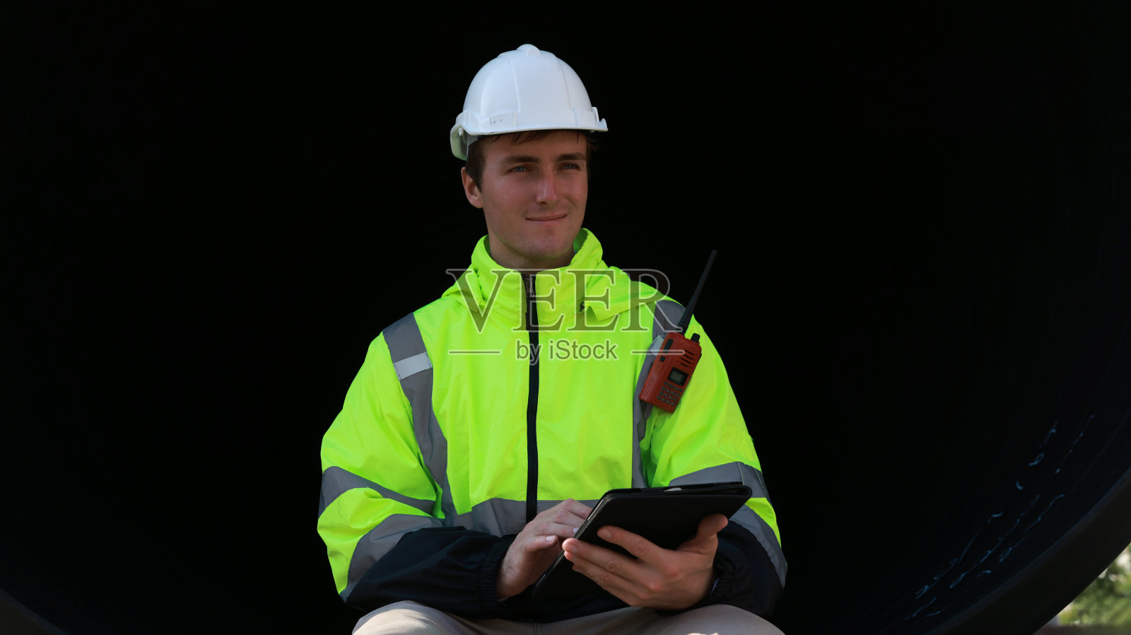 智能工程师在施工现场用通讯设备、施工车辆进行施工排污管道的检修照片摄影图片