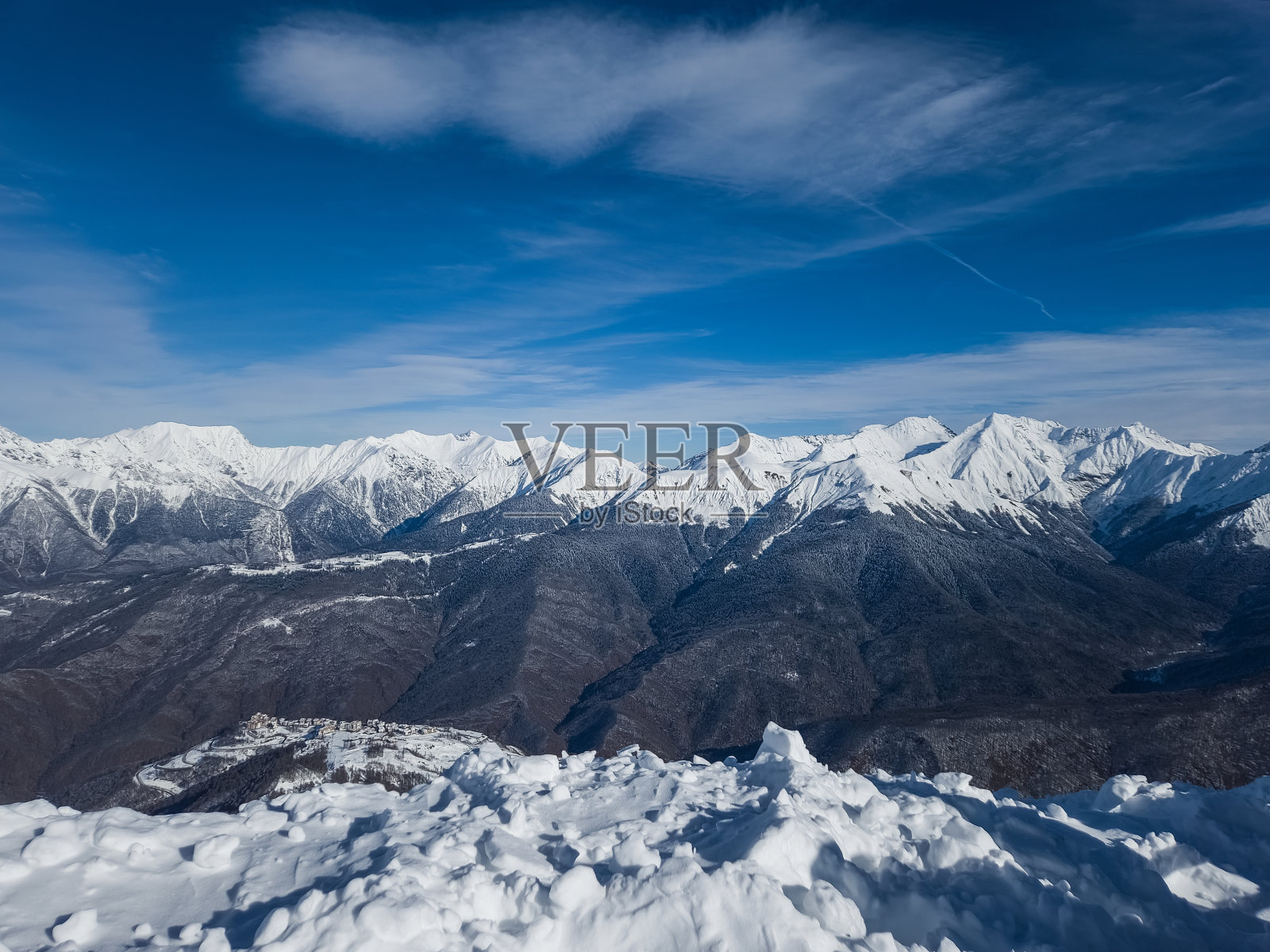 山峰在雪中。山峦和风景被白雪覆盖，映衬着天空。照片摄影图片