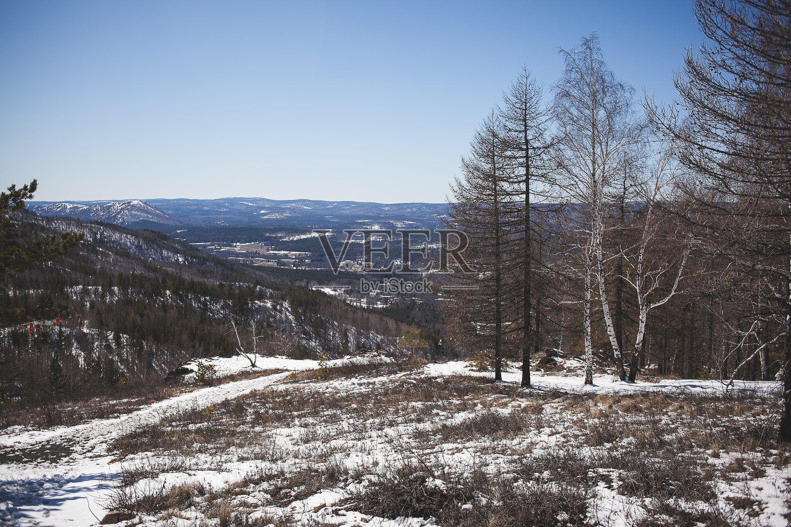 冰雪覆盖的岩石斜坡，山谷，城镇和雪山的壮丽景色照片摄影图片