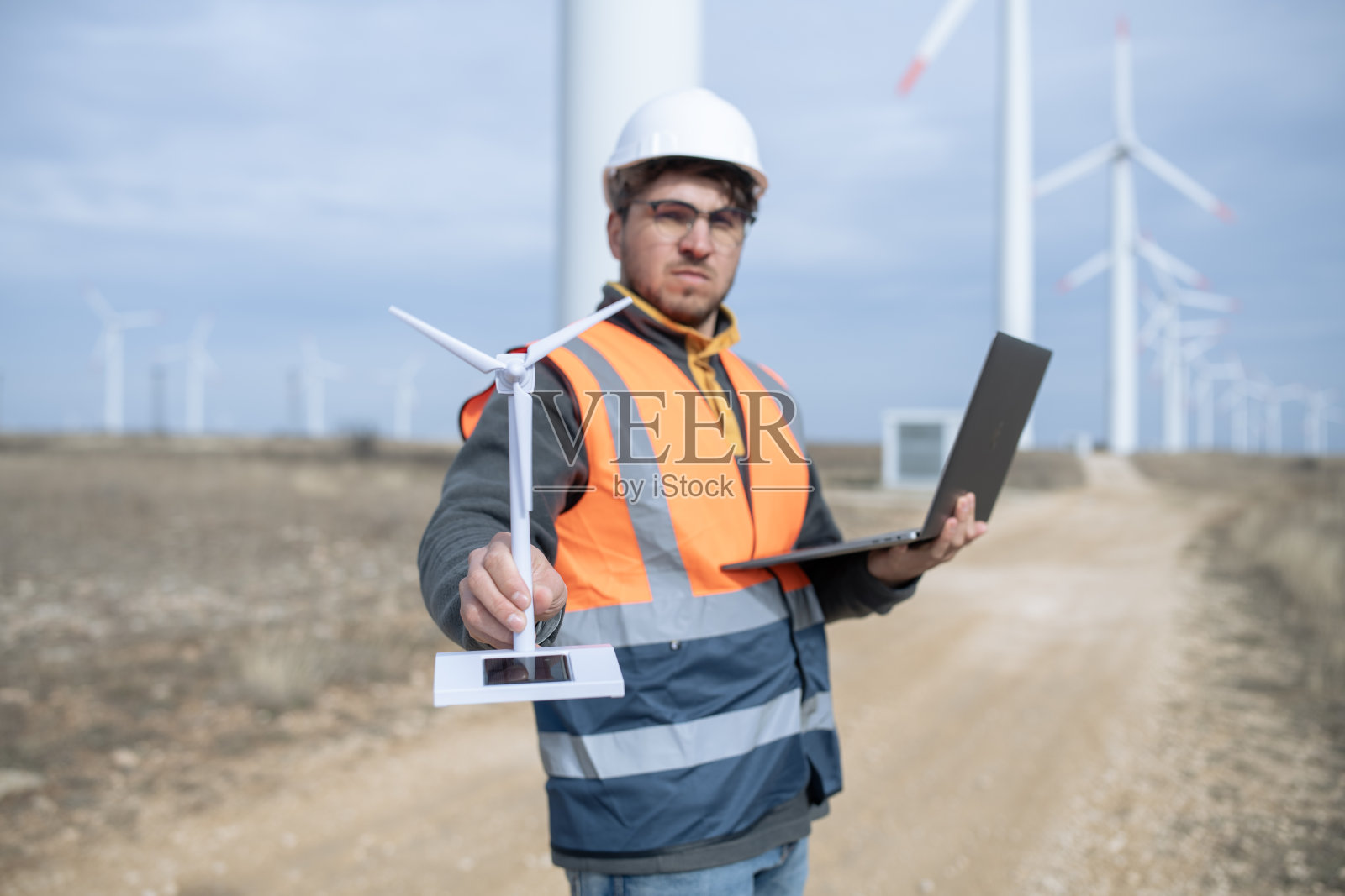 电力工程师在风车农场展示风力涡轮机的小布局。照片摄影图片