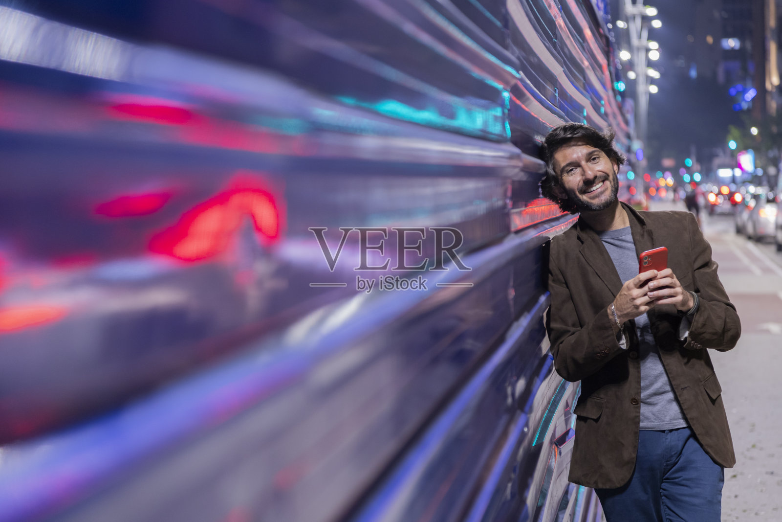 一个拿着智能手机的年轻人照片摄影图片