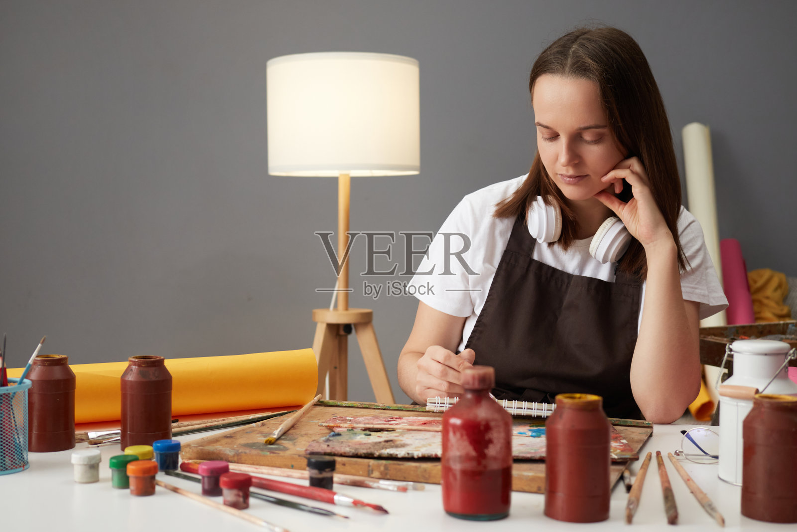 专业的艺术和才华。手工艺的艺术灵感。通过绘画的创造性表达。穿着棕色围裙的白人妇女在艺术创意工作室里画画照片摄影图片