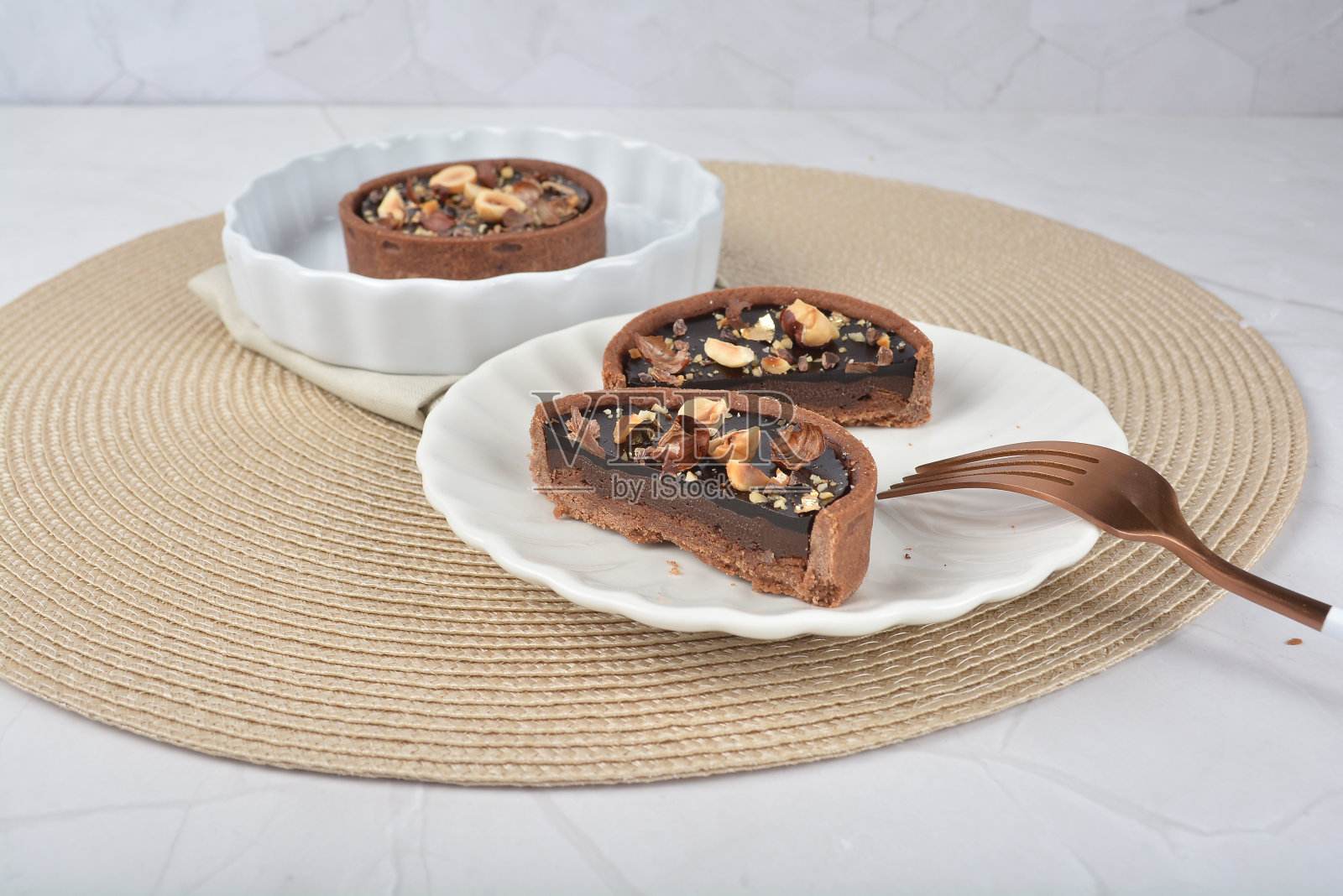 新鲜手工制作美丽的法国rocher黑巧克力层挞和混合夏威夷花生白色大理石豪华背景与竹子装饰清真食品甜品菜单的咖啡馆照片摄影图片