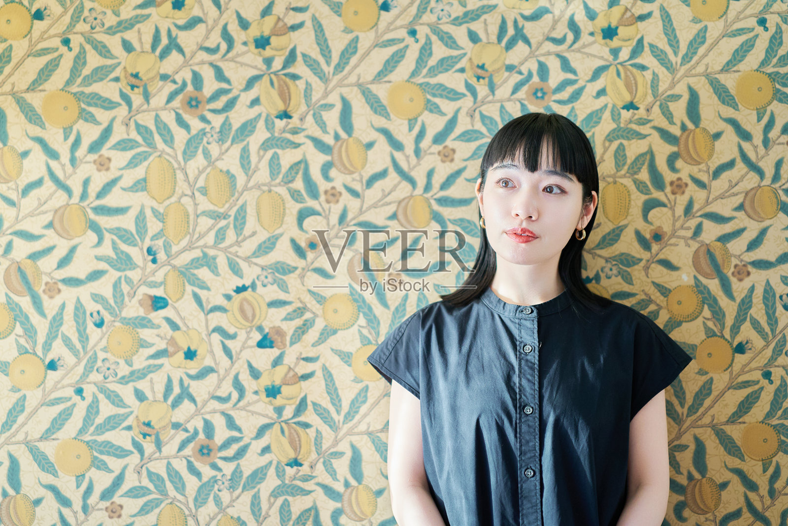 年轻女子和花卉背景墙照片摄影图片