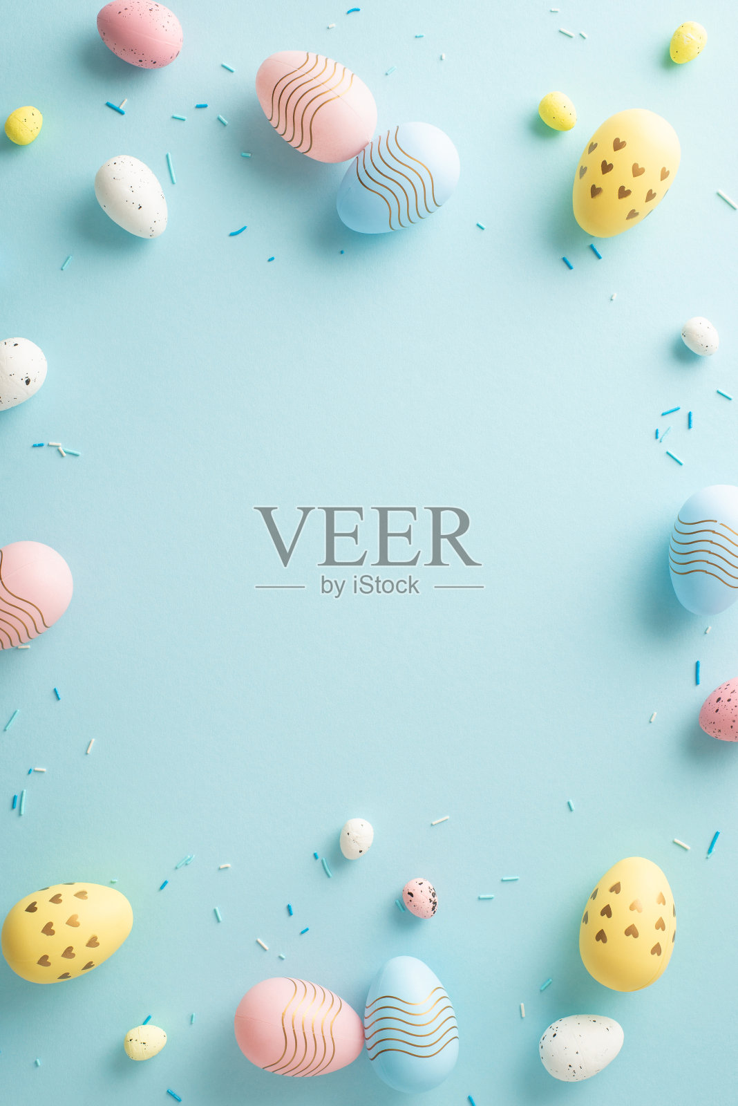 令人愉快的节日气氛。垂直俯视图，空的表面被糖屑和欢快的鸡蛋围绕在柔和的蓝色表面上。足够的空间为您的衷心信息或宣传内容照片摄影图片