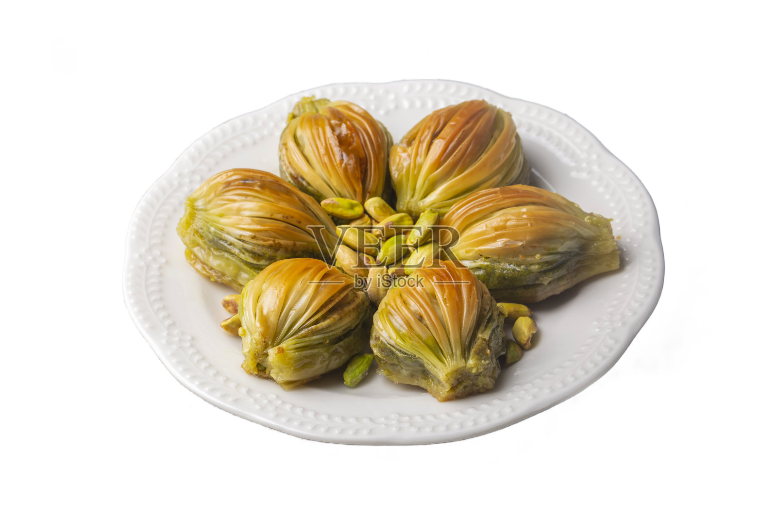 土耳其米耶果仁蜜饼(贻贝形状果仁蜜饼)与绿色开心果粉和黄油奶油。伊斯兰节日的概念。照片摄影图片