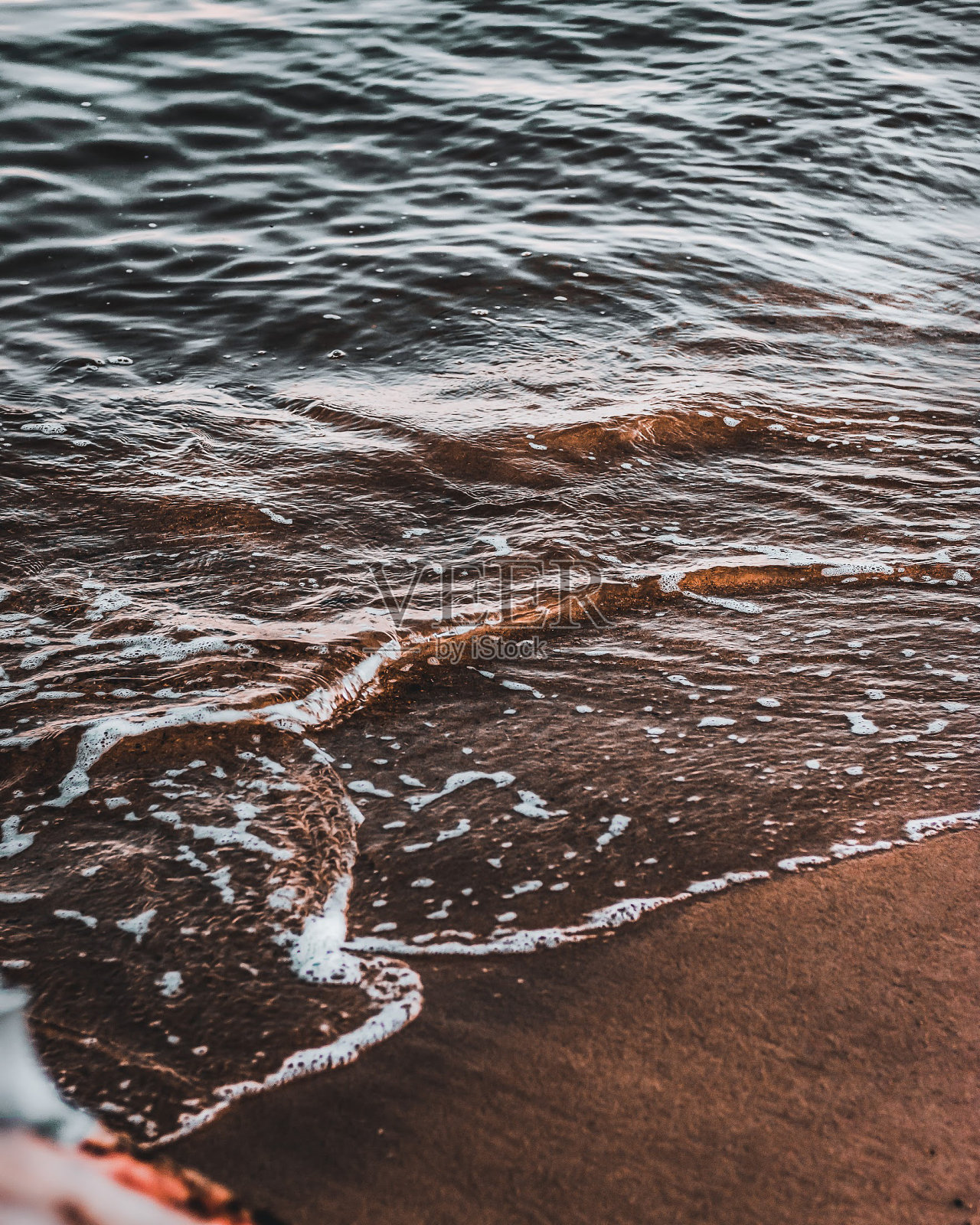 炽热的告别:太阳在戏剧性的海滩日落地平线以下照片摄影图片
