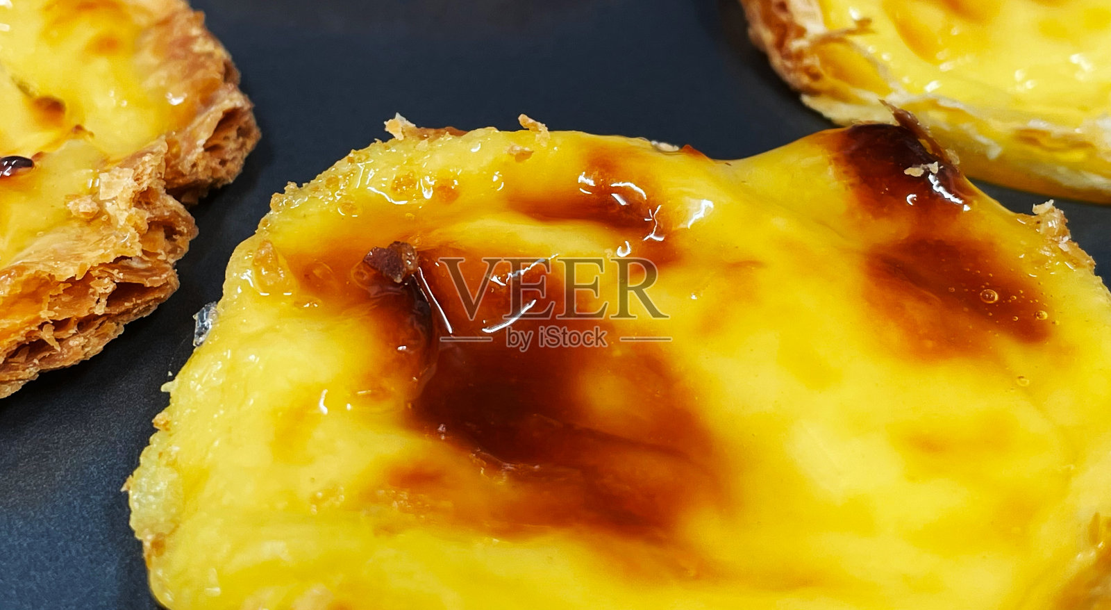 许多新鲜出炉的蛋挞或葡萄牙蛋挞甜点在烤盘。Belme派是一种小馅饼，外皮酥脆，内馅是蛋奶冻。小蛋糕。照片摄影图片