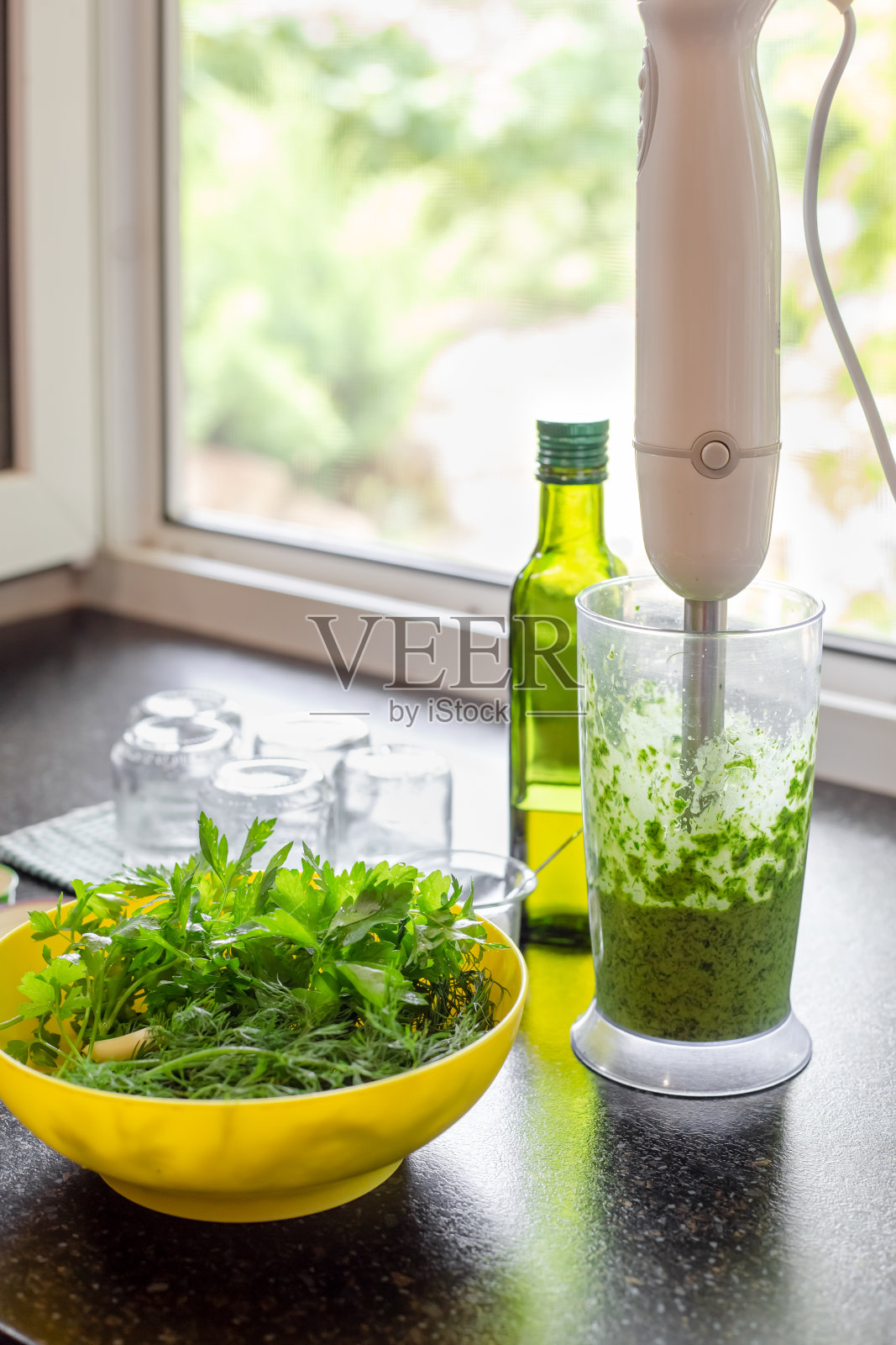 用香草和橄榄油做酱汁。一杯欧芹和莳萝，在搅拌机和一个玻璃容器中研磨香草。为冬天做准备照片摄影图片