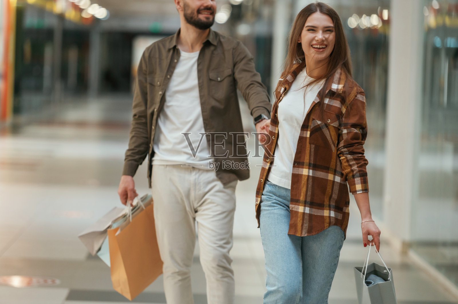 那家伙不想去购物。一对年轻的夫妇一起在超市照片摄影图片