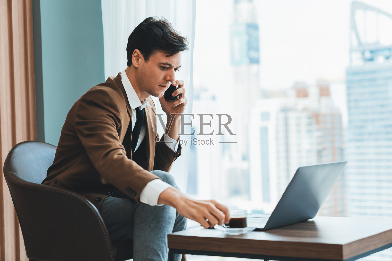 专业商人一边打电话一边用笔记本电脑工作。装饰。照片摄影图片