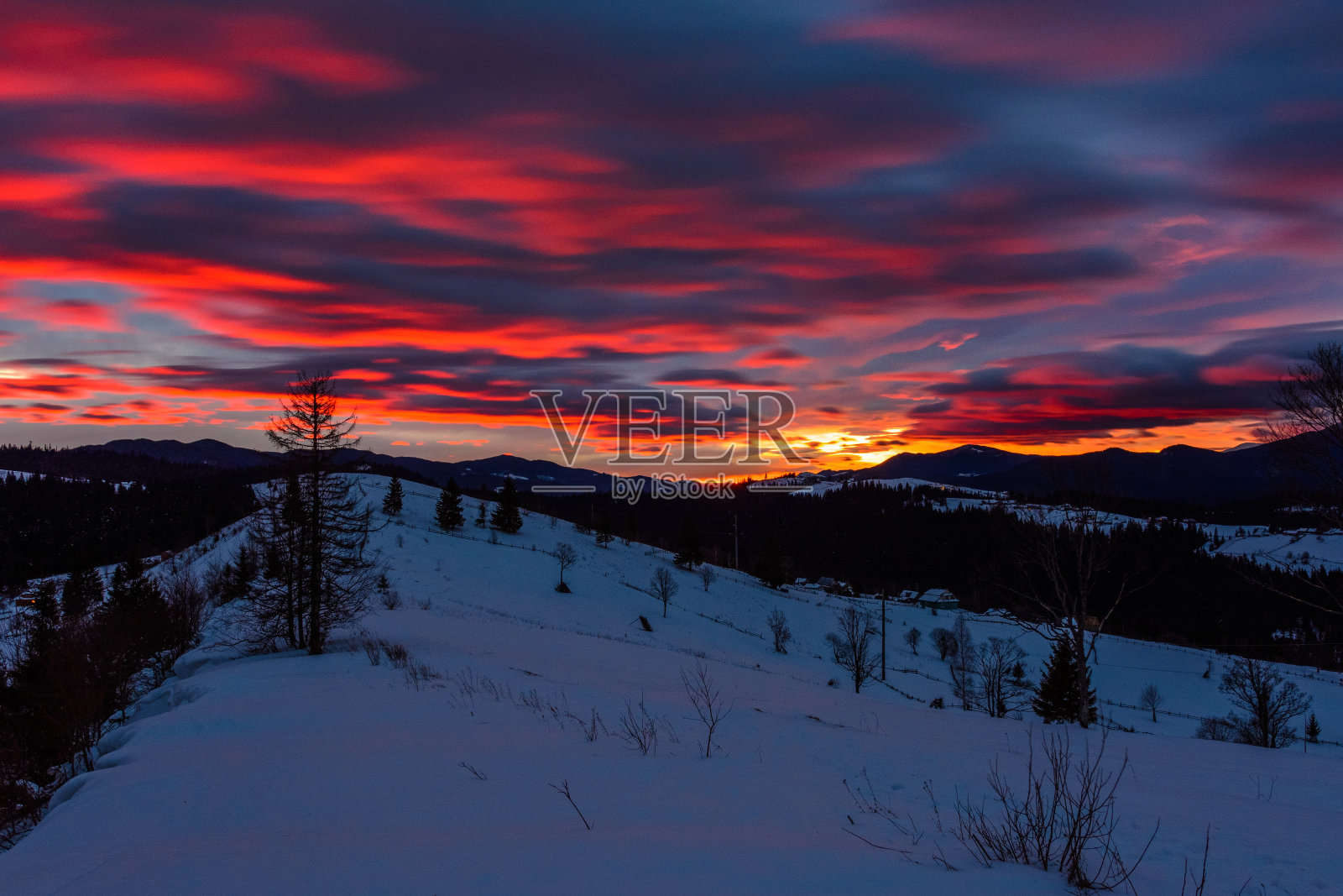 黎明时分喀尔巴阡山脉的壮丽景色和鲜红的云彩照片摄影图片