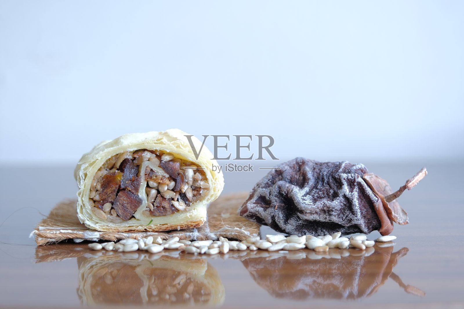 干果和坚果卷。干柿子和葵花籽烤成一个卷。健康能量食品理念照片摄影图片