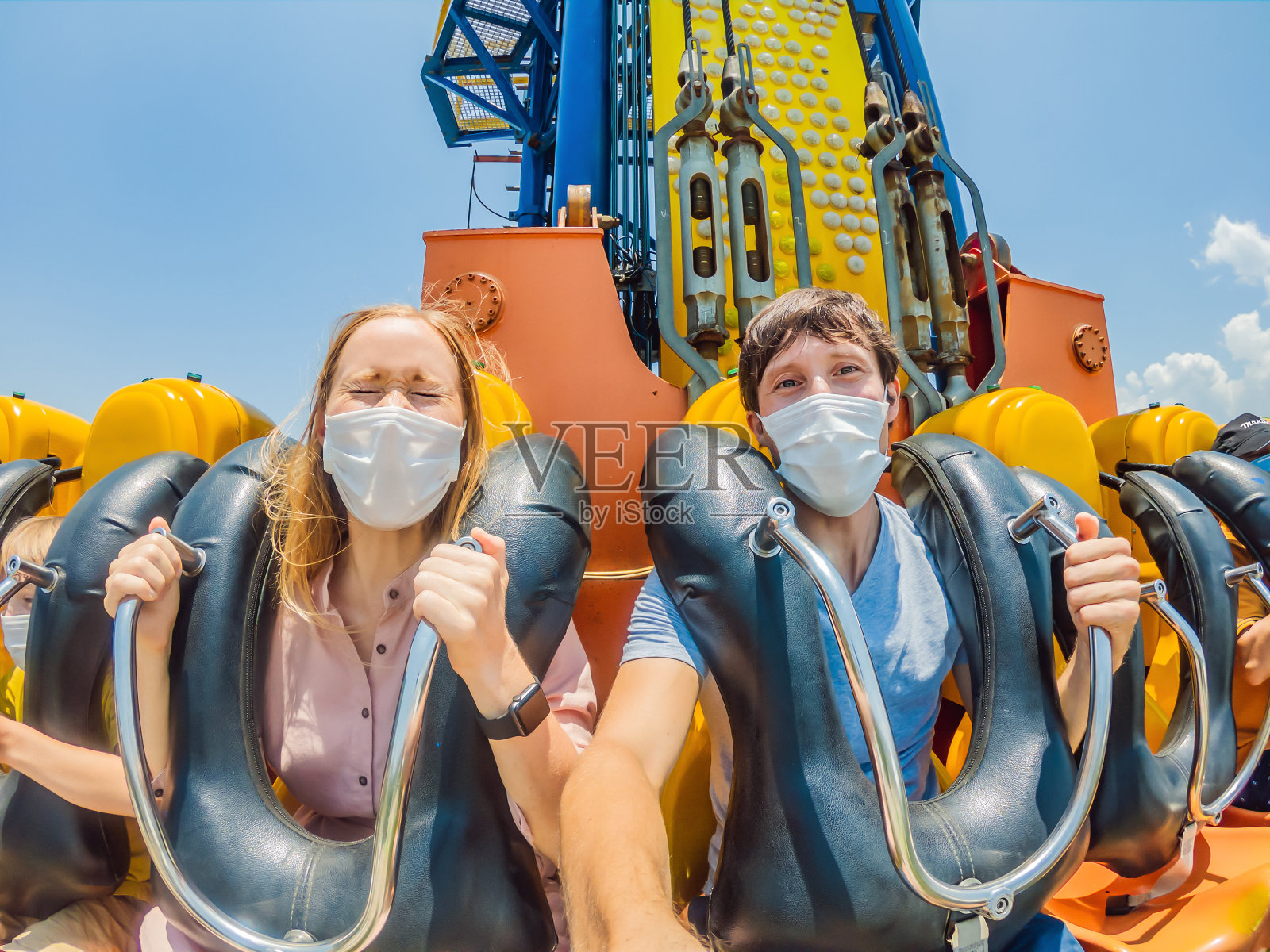 在2019冠状病毒病期间，一家人在游乐园戴着医用口罩照片摄影图片