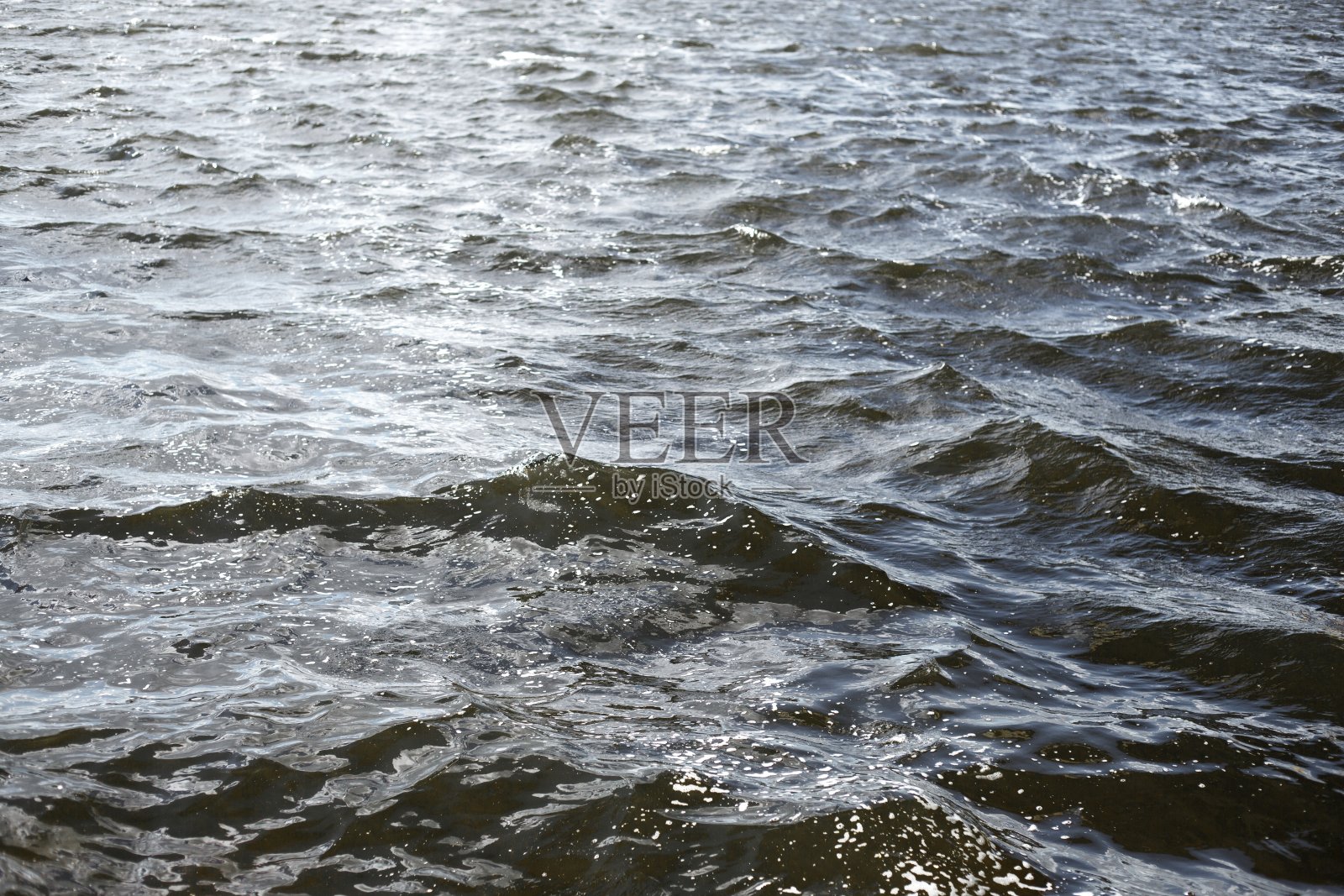 海面鸟瞰图。背景拍摄清澈的海水表面。湛蓝的海水在平静。背景是蓝色的海浪照片摄影图片