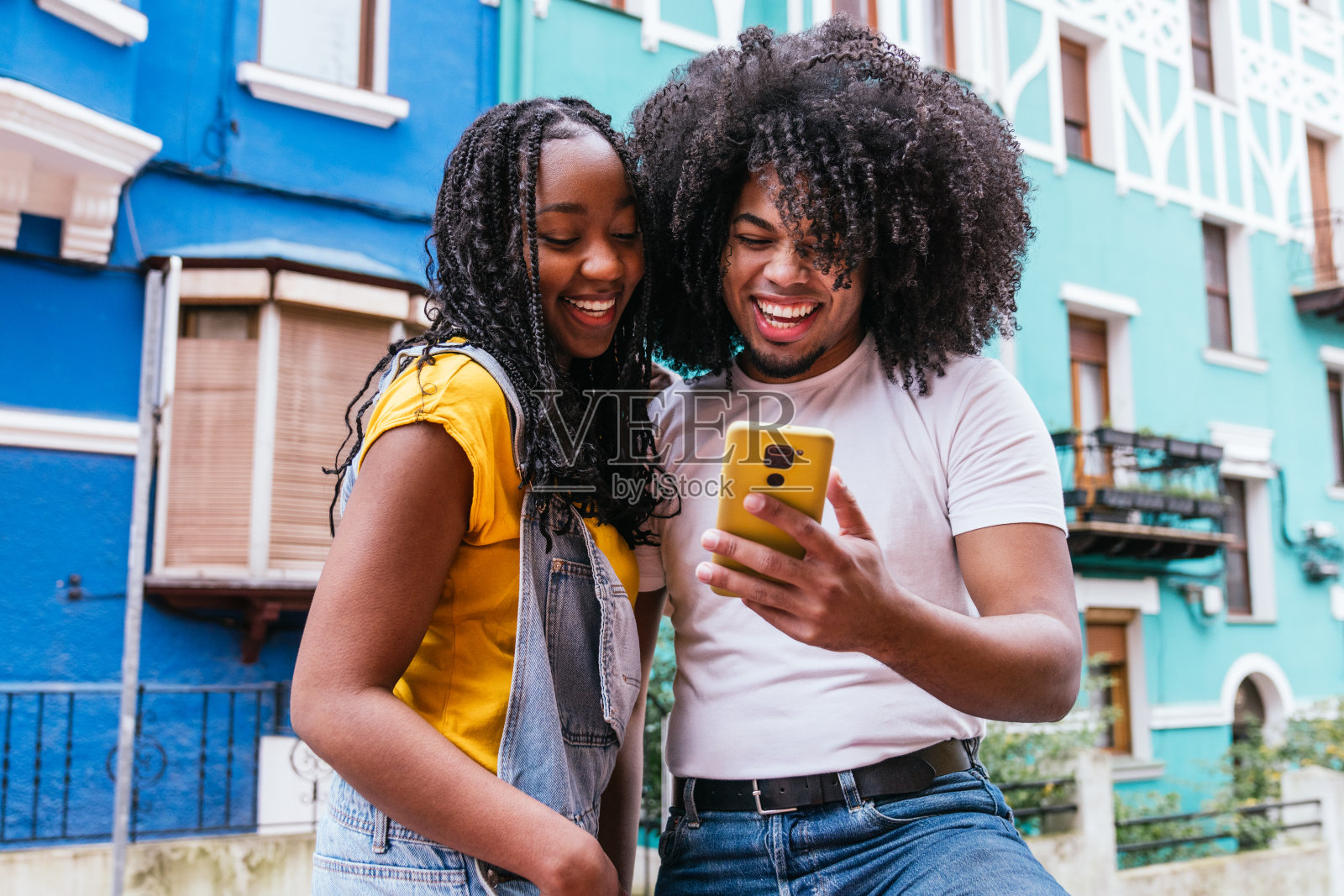 快乐时刻:朋友们用智能手机分享欢笑照片摄影图片