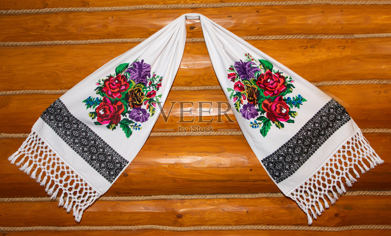 毛巾挂在装饰着美丽花朵的木墙上照片摄影图片