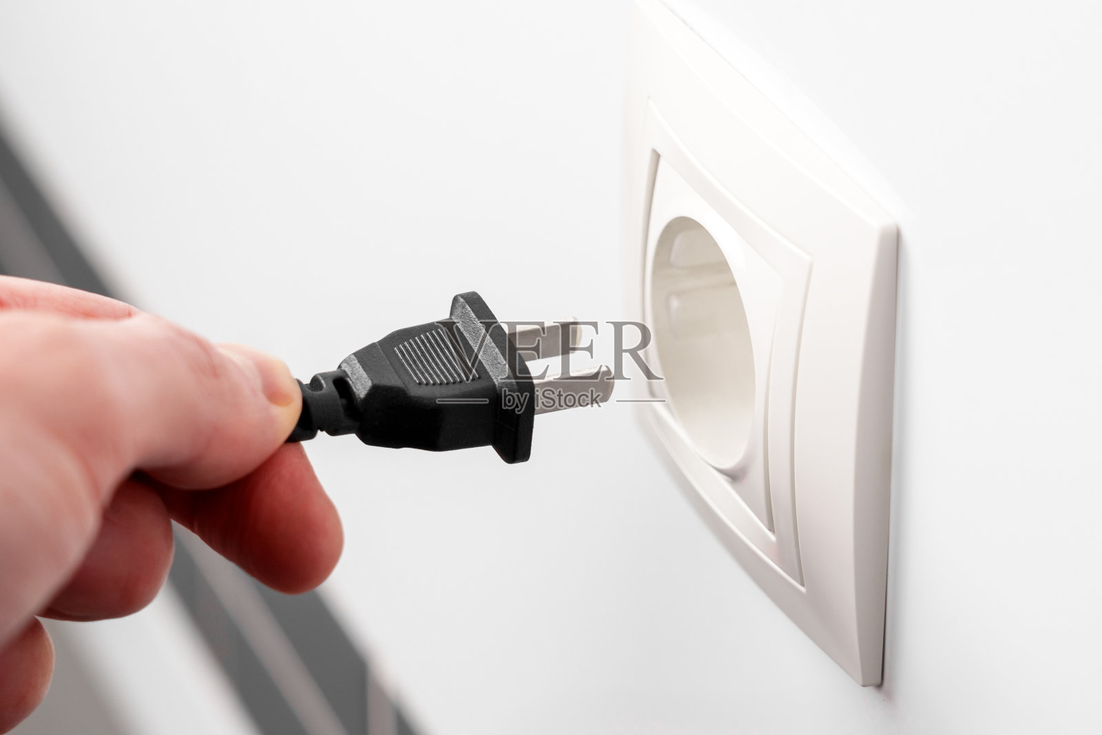 手持电源插头和家用电源插座照片摄影图片