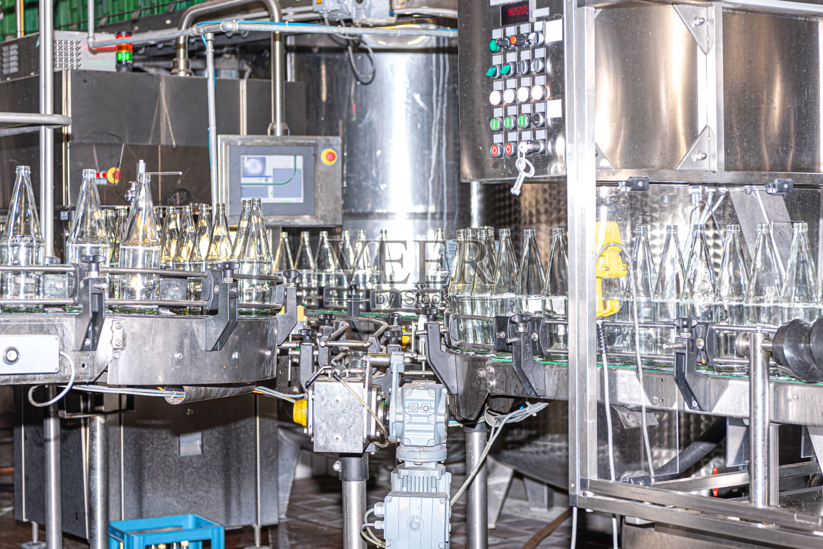 在填充之前，玻璃饮料瓶在专用的工业洗碗机中进行彻底的清洁过程照片摄影图片