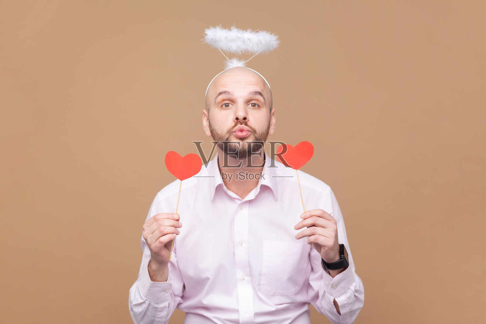 调情浪漫的秃顶大胡子，头顶灵巧，拿着红色的小心形，送飞吻照片摄影图片