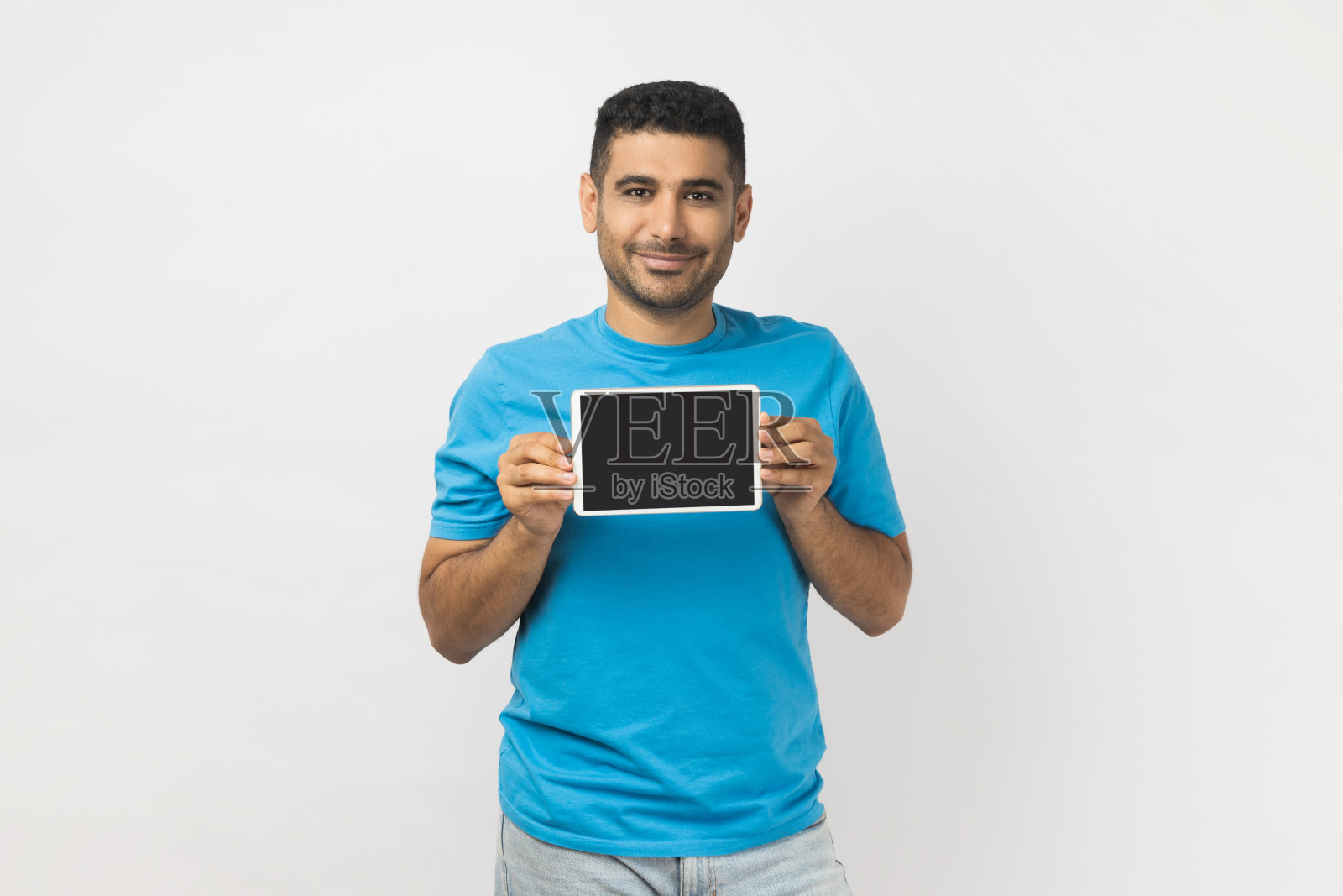 乐观的男子展示带黑色屏幕的平板电脑，广告区域照片摄影图片