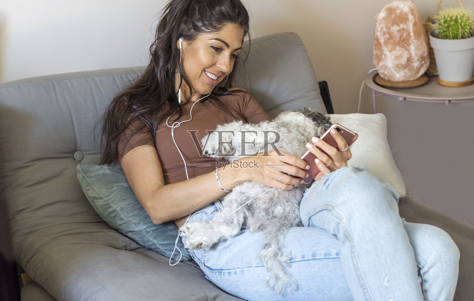 微笑的女人在家里用手机照片摄影图片
