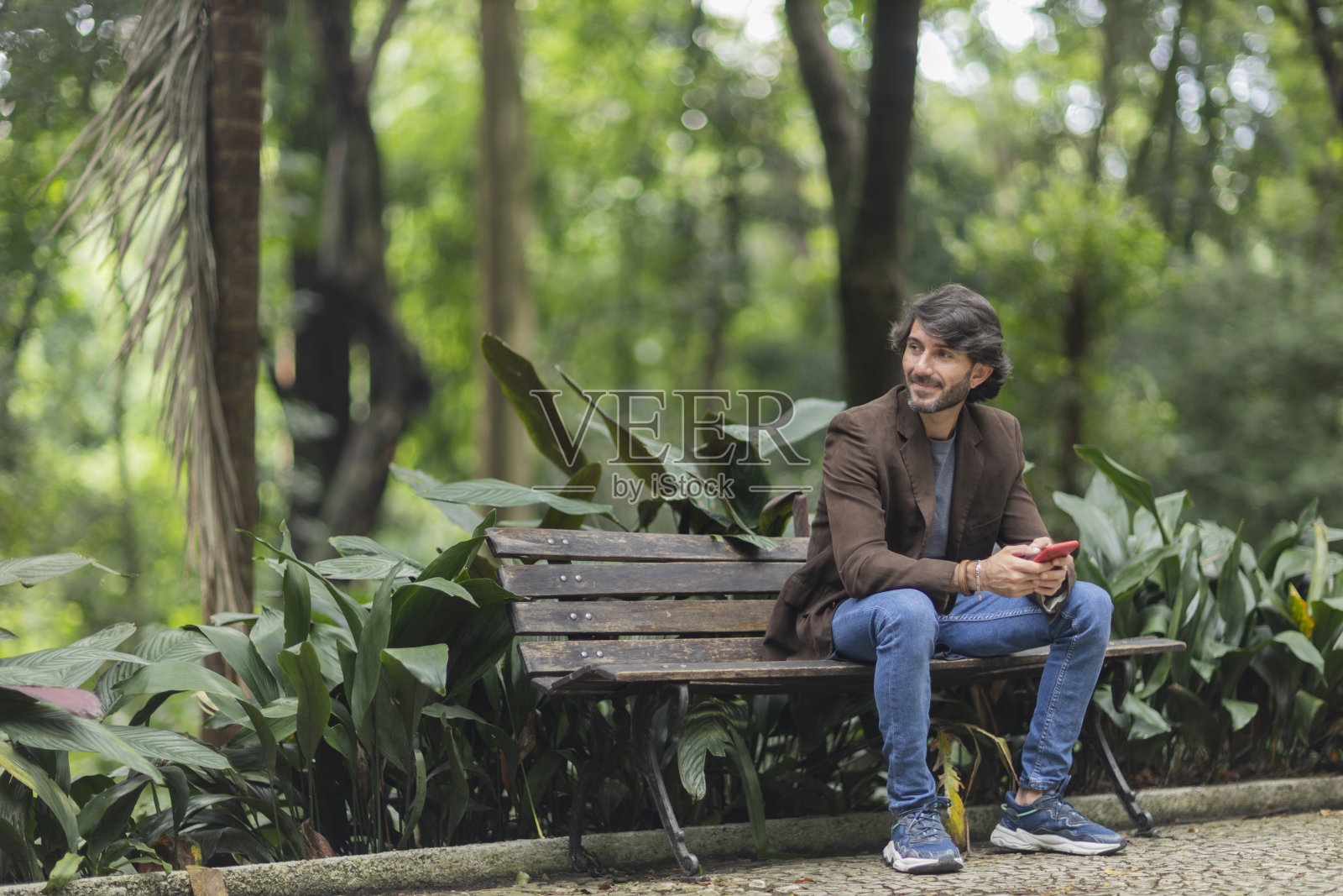 一个拿着智能手机的年轻人照片摄影图片