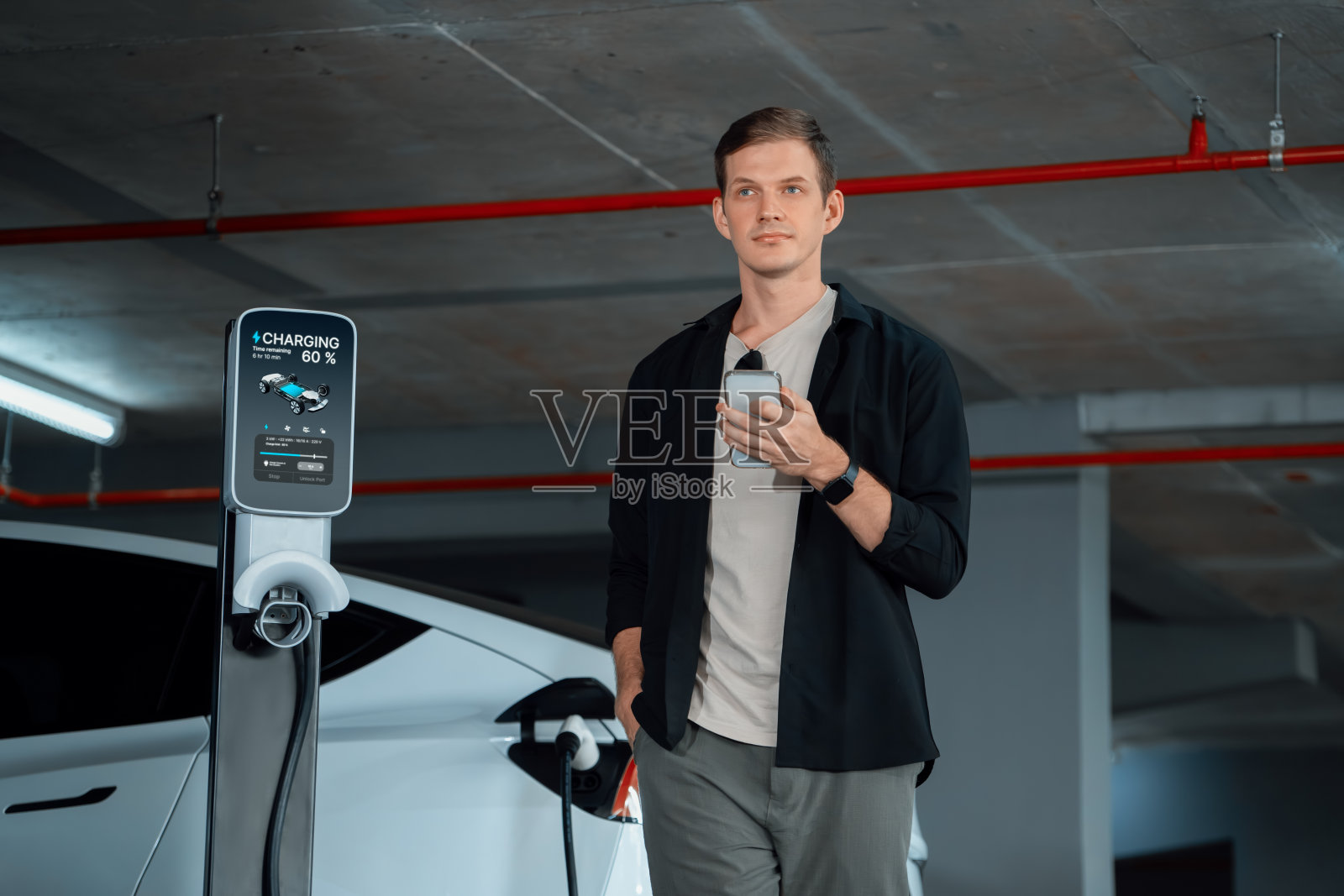 年轻人开着电动汽车到购物中心停车场内部照片摄影图片