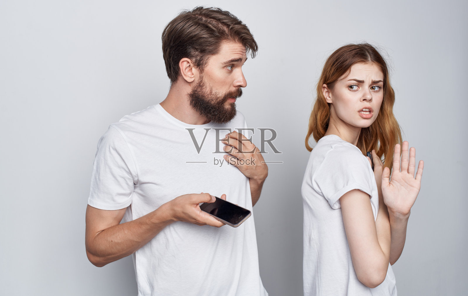 一男一女穿着白t恤，手里拿着手机，浪漫的通讯技术照片摄影图片