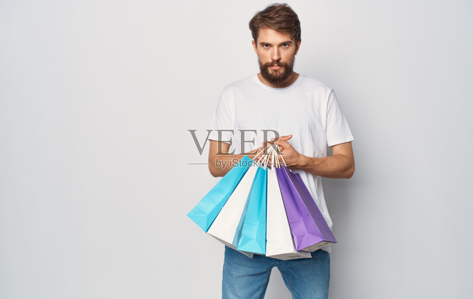 身穿白色t恤、手持包裹的大胡子男子的剪影照片摄影图片