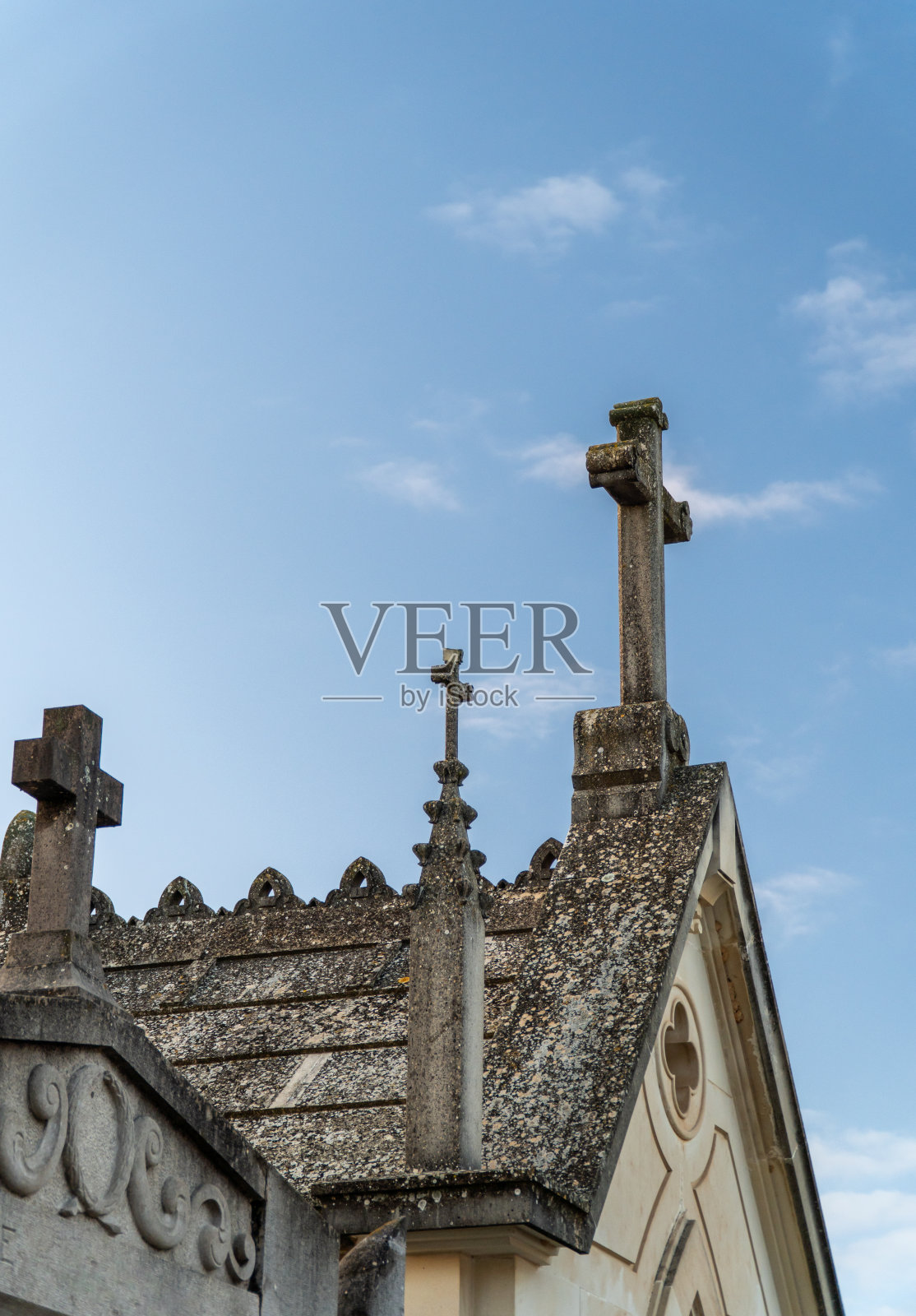 墓地里古老的石头十字架，映衬着蓝天照片摄影图片