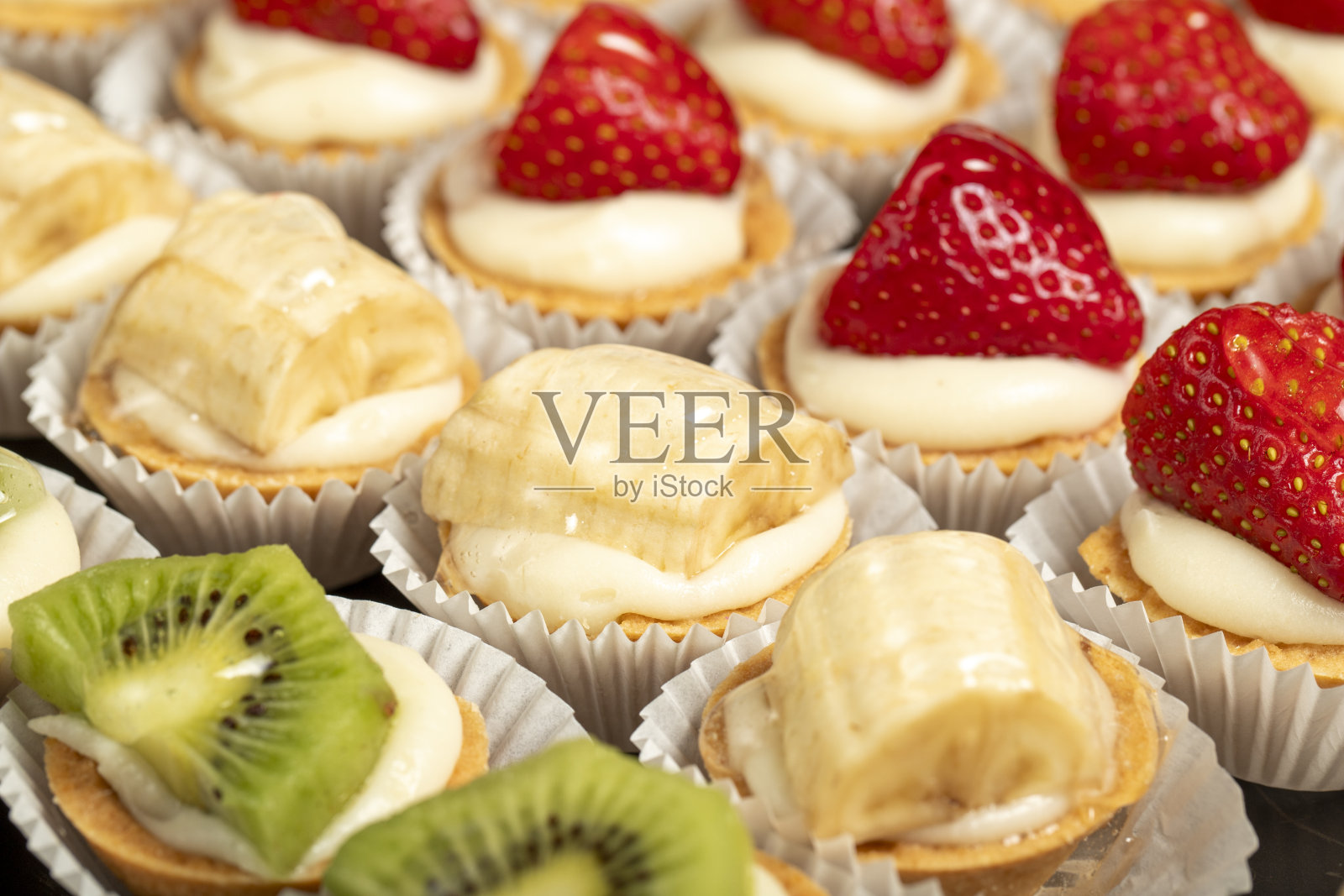 小果馅饼类型。糕点产品。白色背景的猕猴桃、香蕉和草莓馅饼。本地名称。近距离照片摄影图片