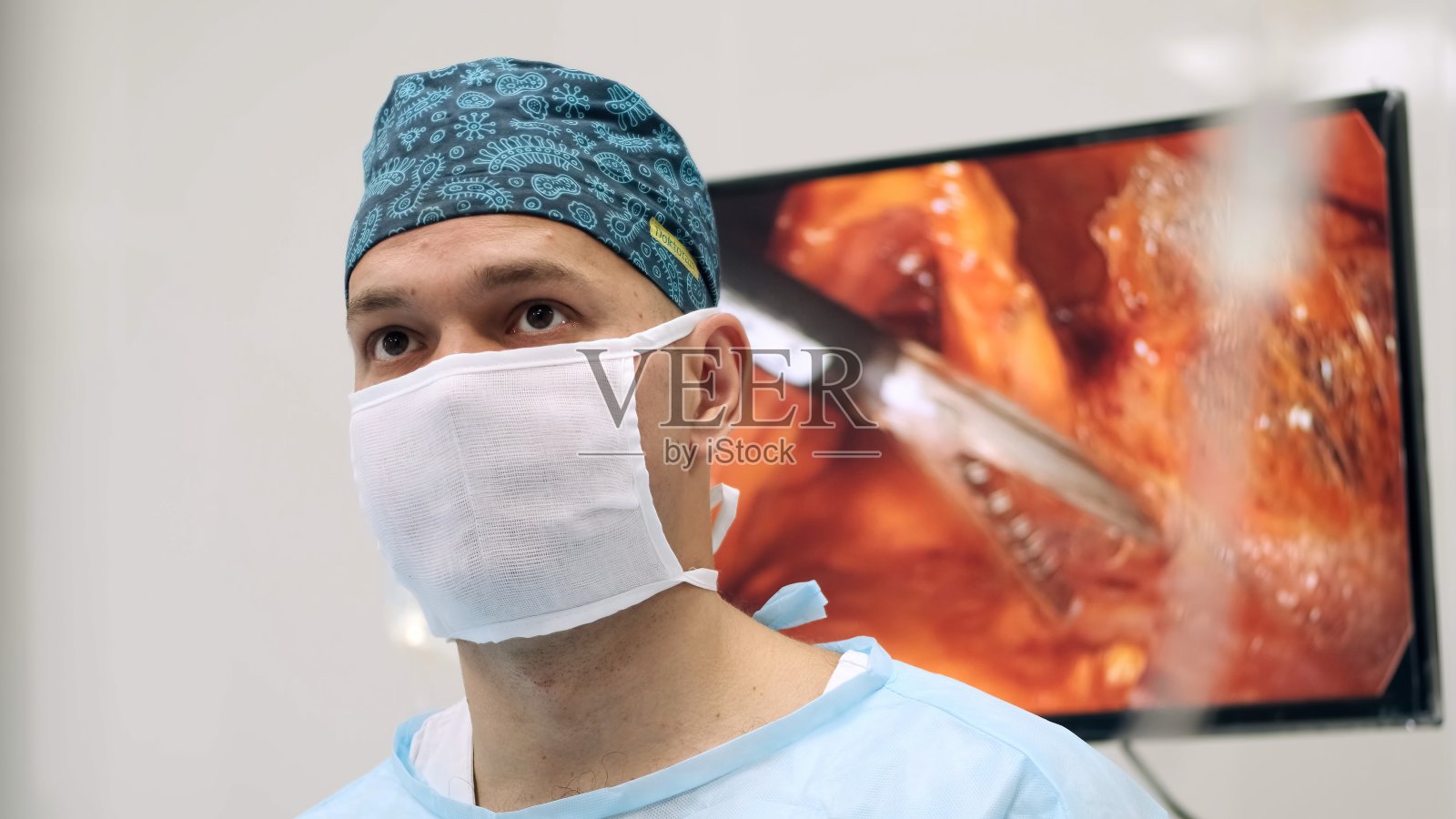 手术时，外科医生在手术室里看着一个大屏幕。现代医学技术照片摄影图片