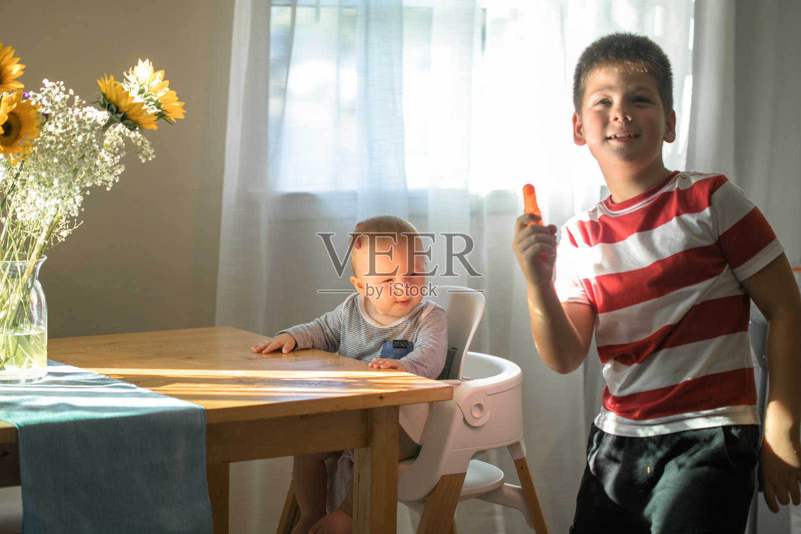 哥哥和他的小男孩玩。两个兄弟姐妹。美丽可爱的家庭在爱，可爱的婴儿和孩子在家里玩，在室内。照片摄影图片