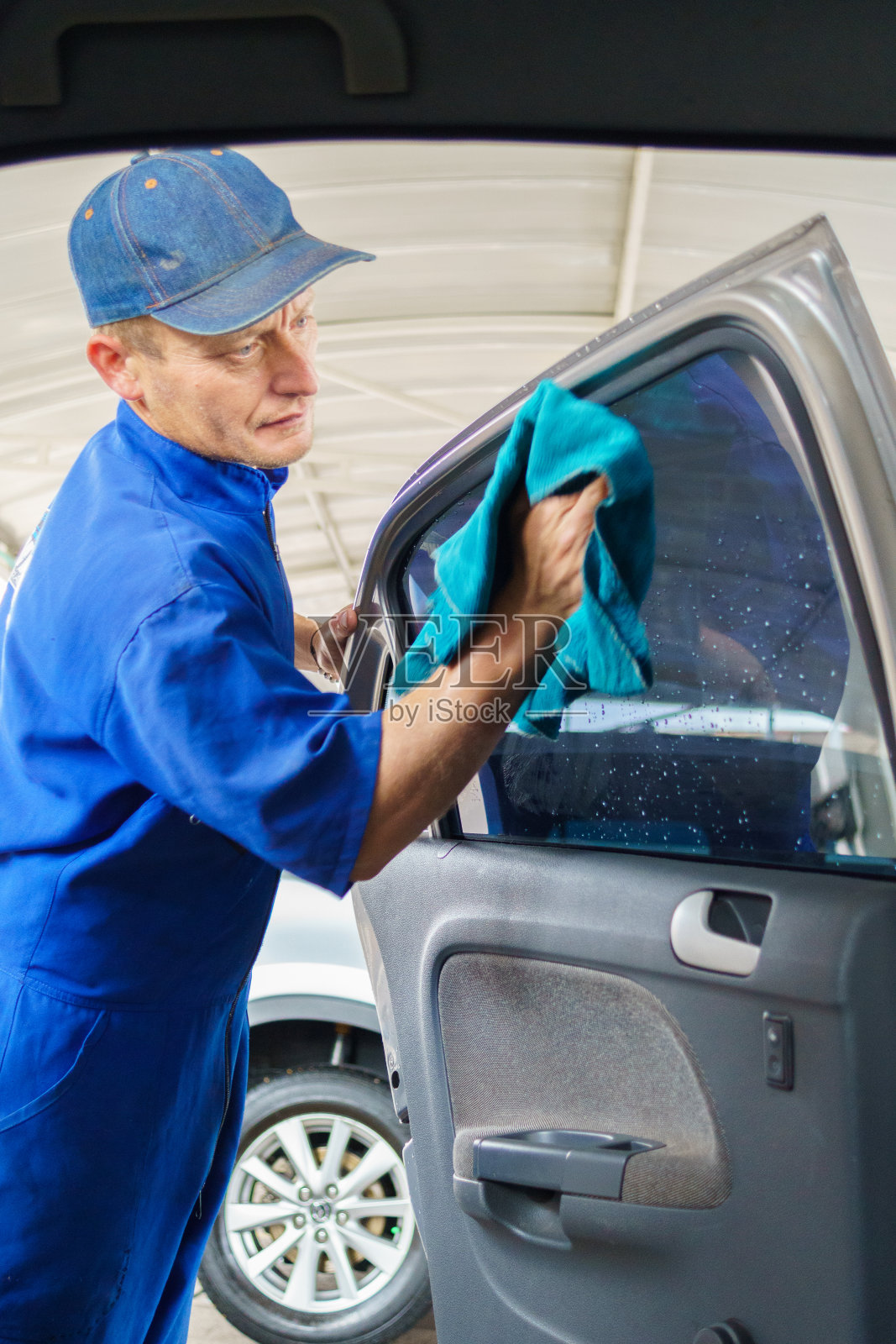 洗车工人正在清洗汽车后门内侧的玻璃照片摄影图片