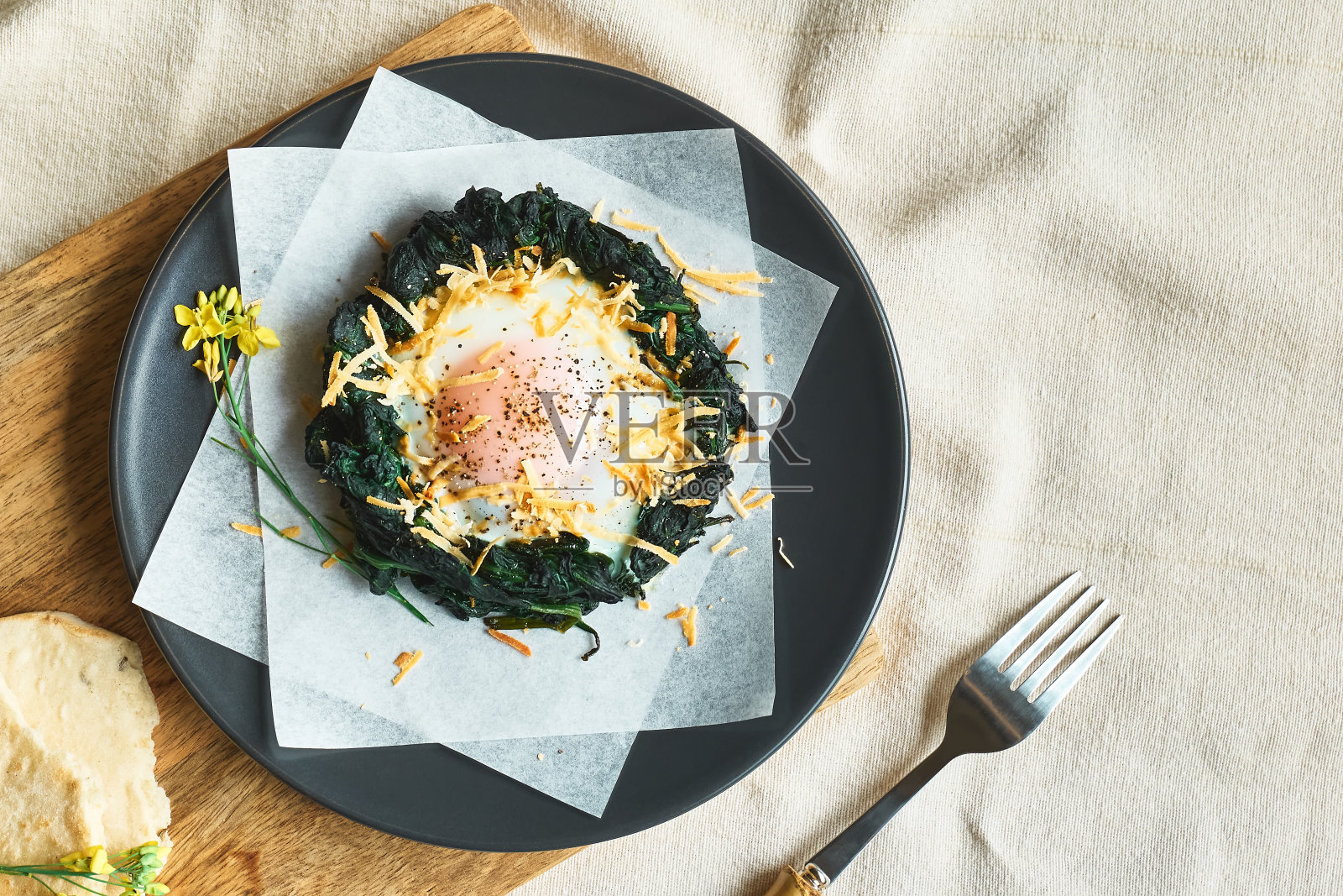 复活节早餐的主意。用磨碎的奶酪和黑胡椒装饰的烤菠菜蛋巢。节日的食物。孩子们有趣的健康食品。照片摄影图片